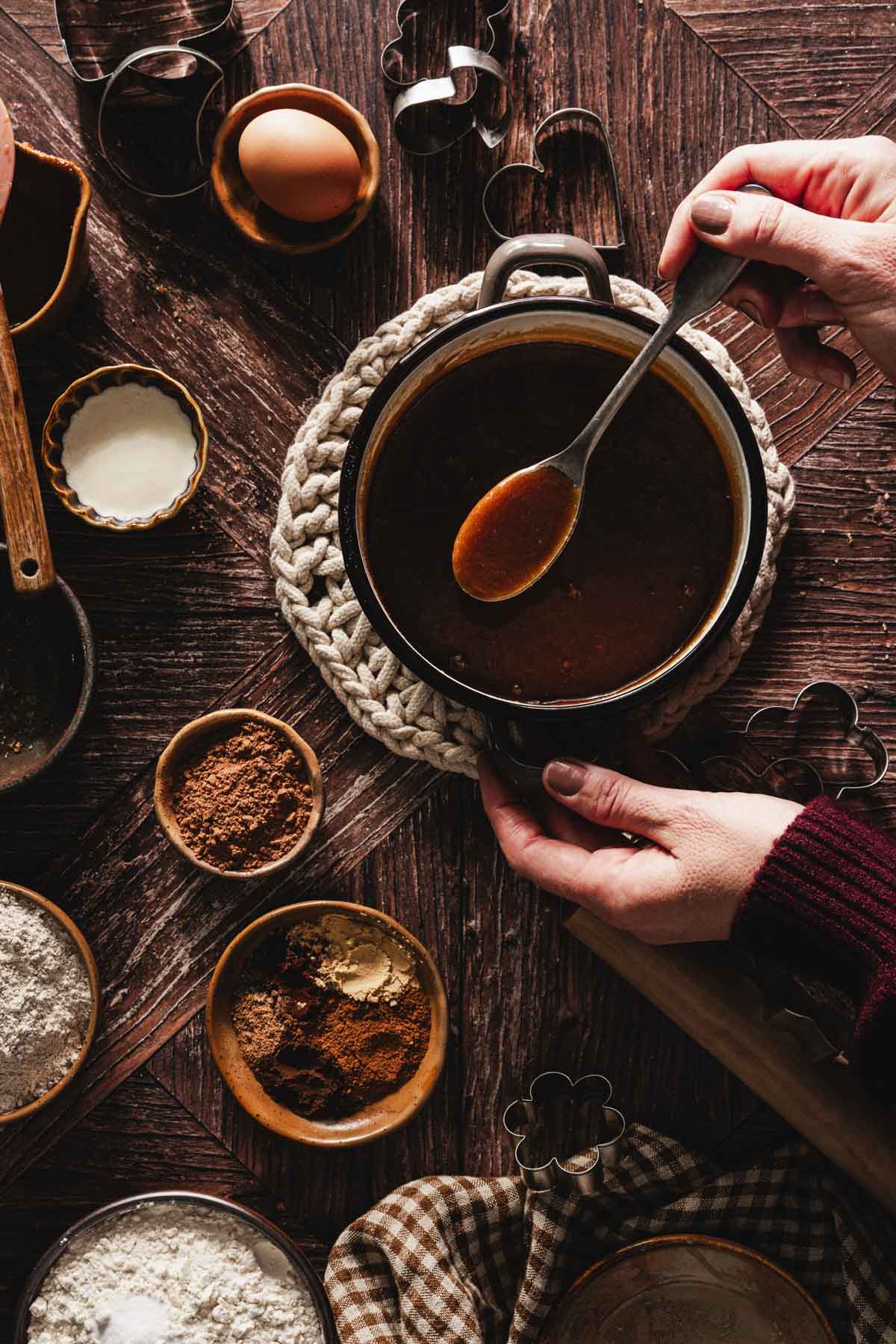 hands in frame hoding spoonover saucepan with wet ing