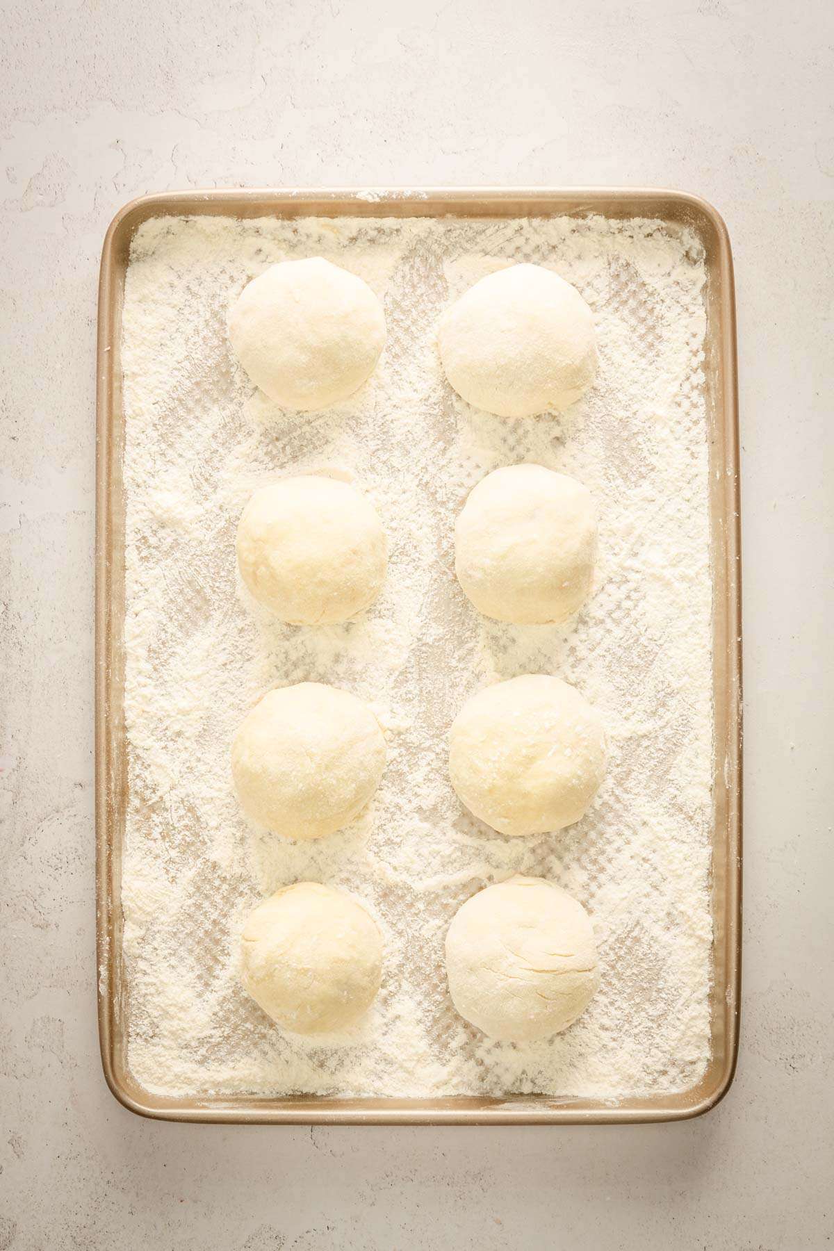 raw formed knedle on a baking sheet