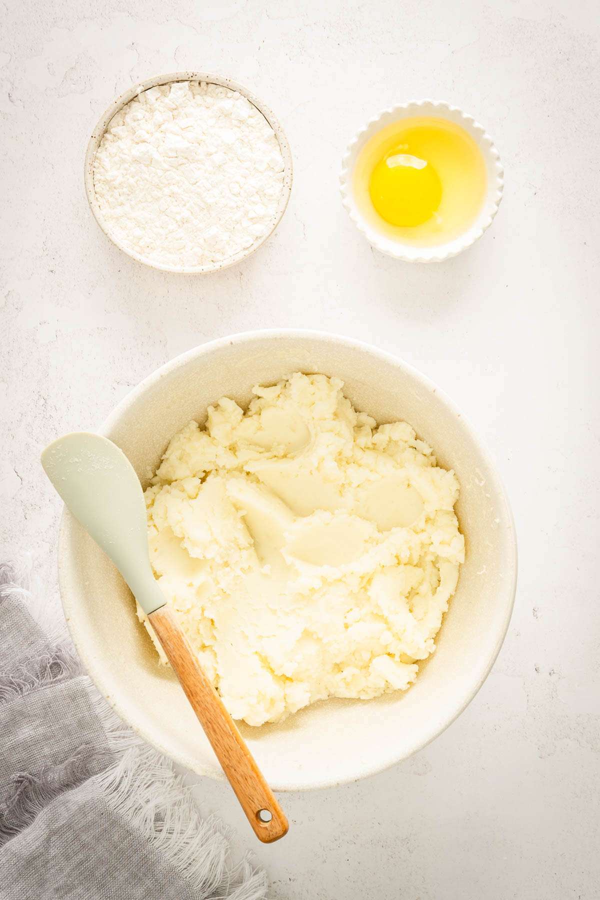 dough for knedle in a mixing bowl, dish with flour and egg