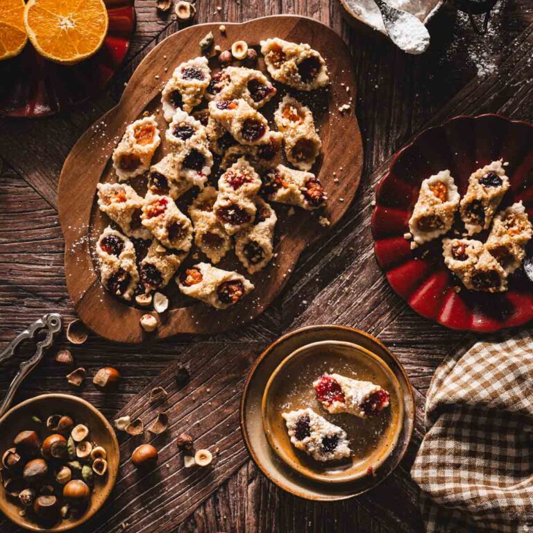 various serving plates with kolaczki cookies