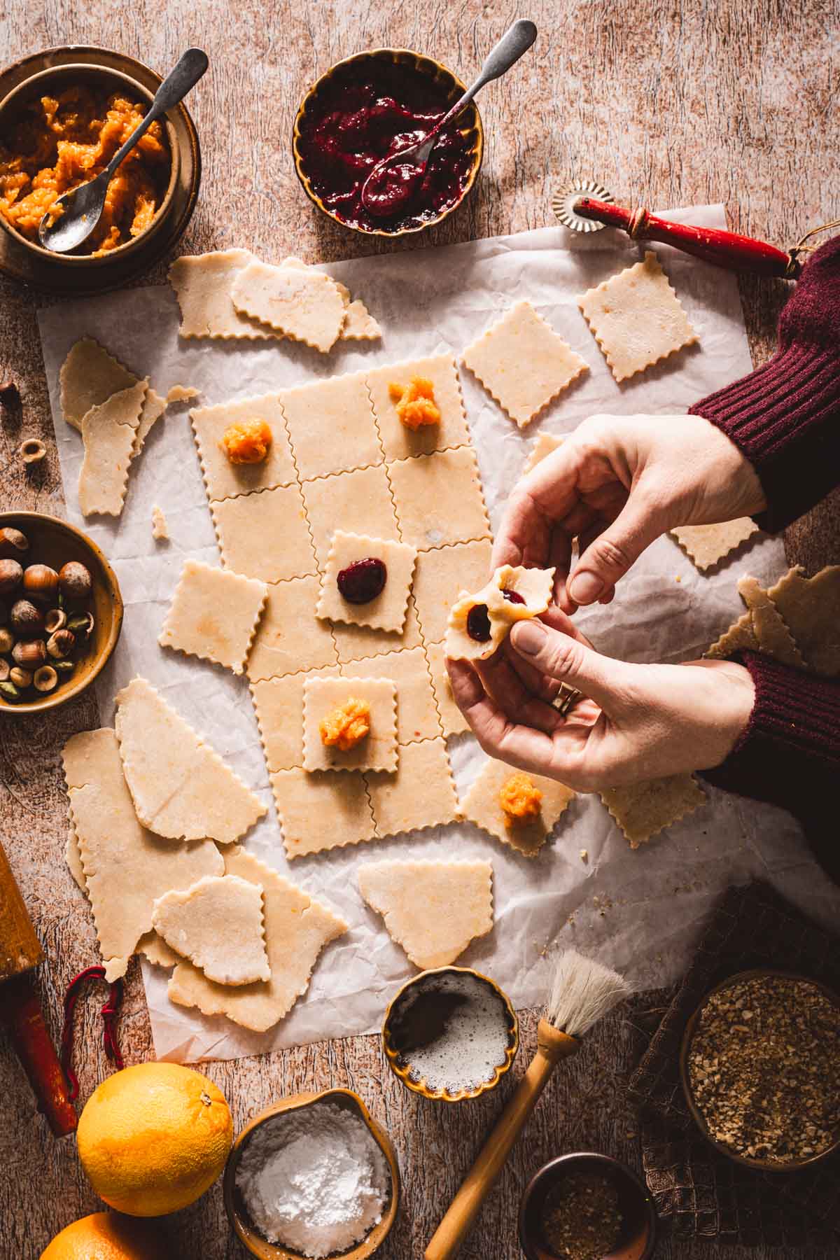 hands in frame holding formed kolaczki cookie