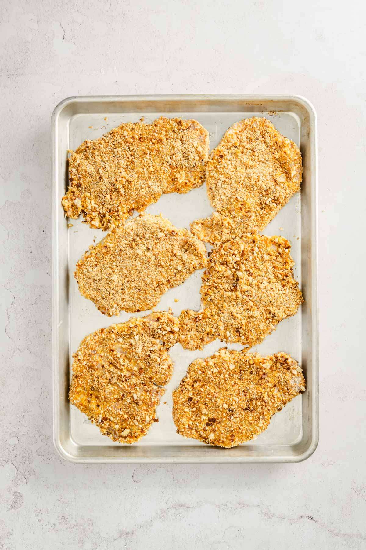 coated pork chops ready for cooking