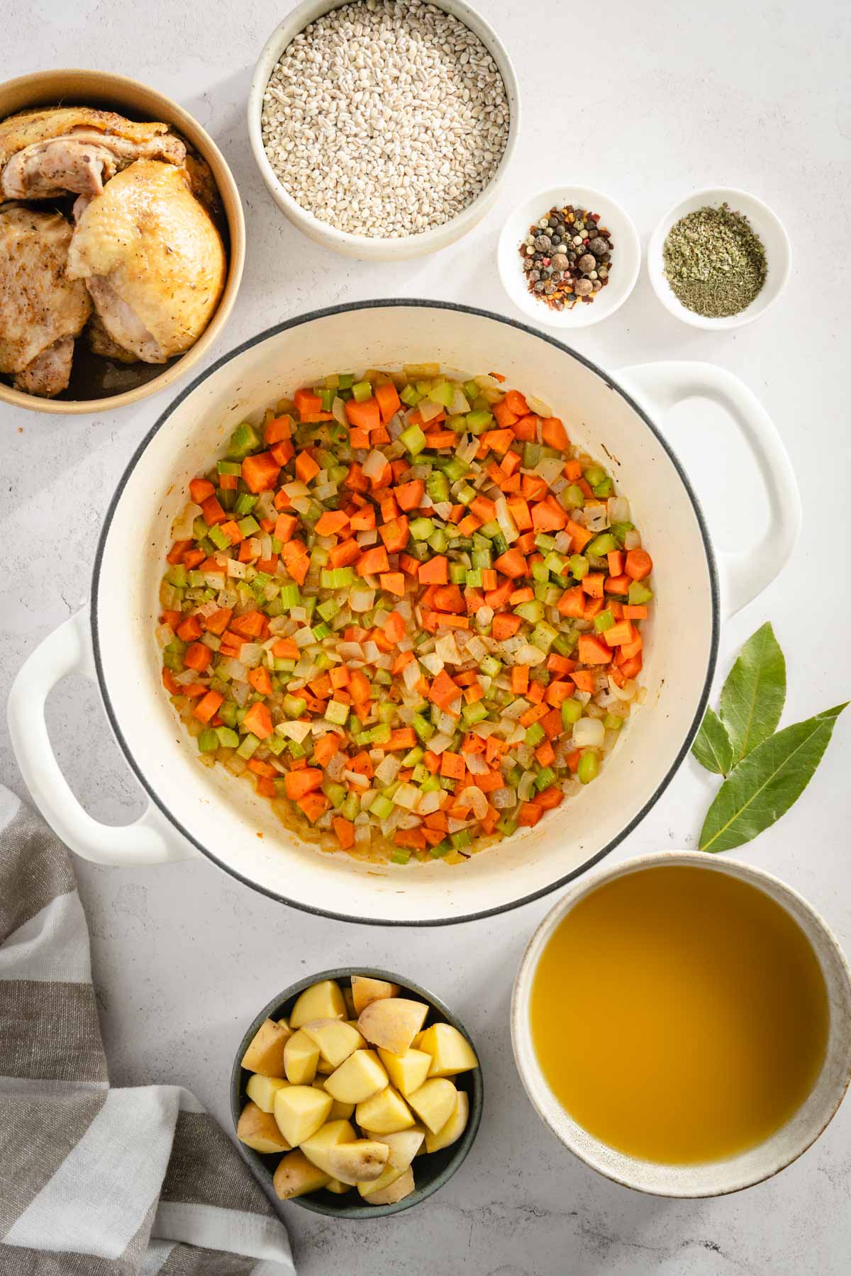 coooked veggies in the pot, rest of the ingredients for Krupnik set around