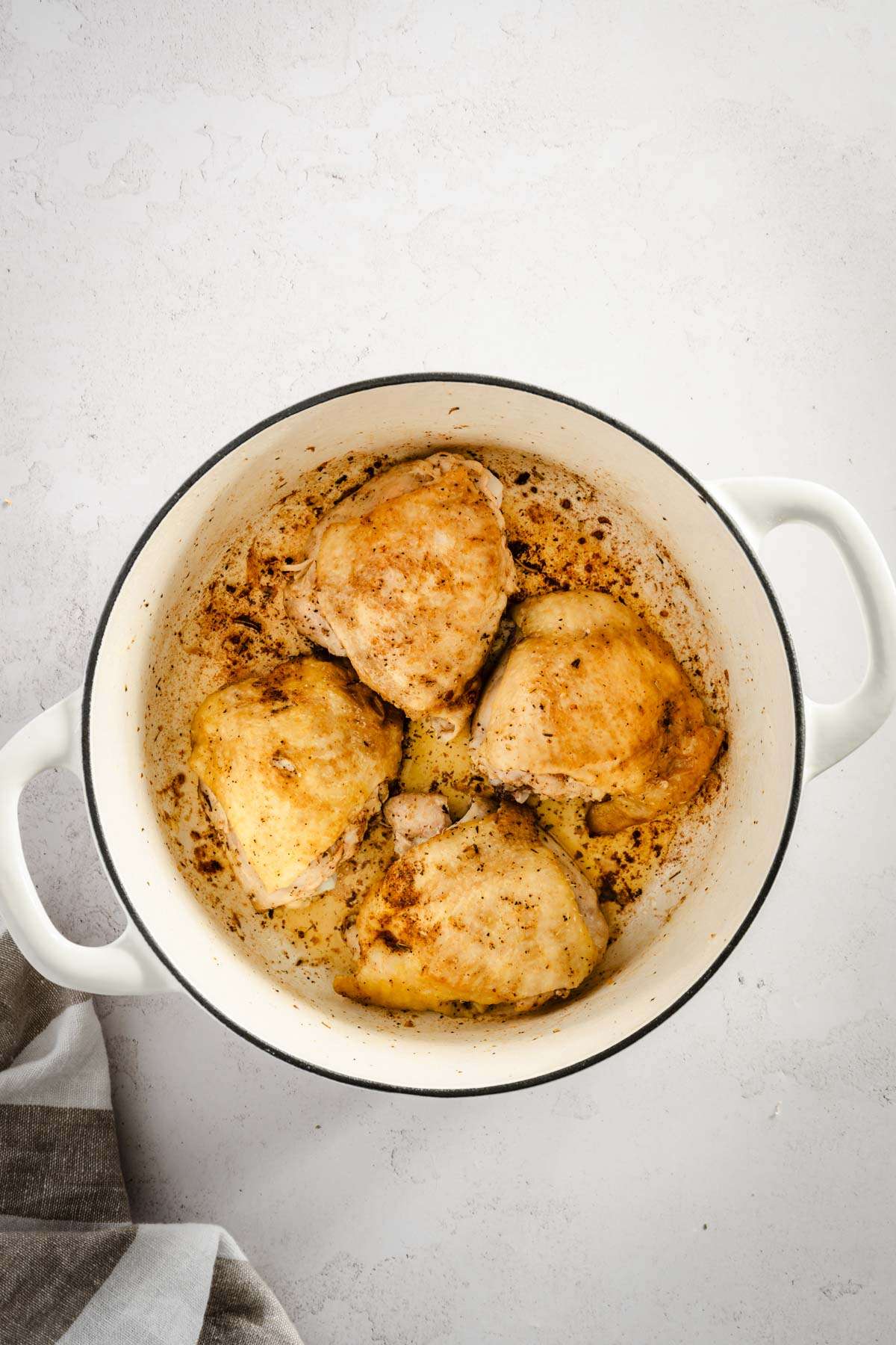 four cooked chicken thighs in the cooking pan