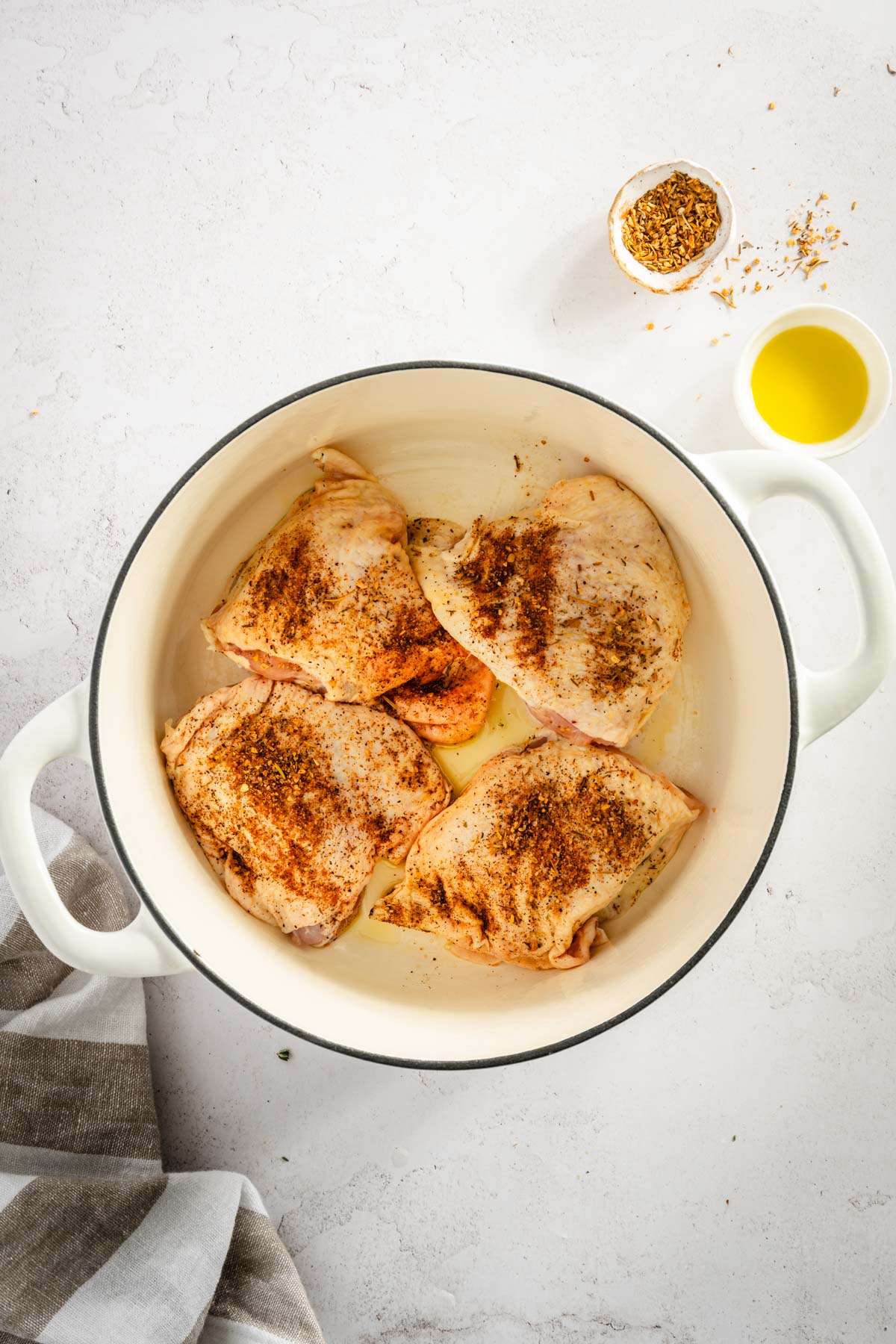 four seasoned chicken thighs in the cooking pan