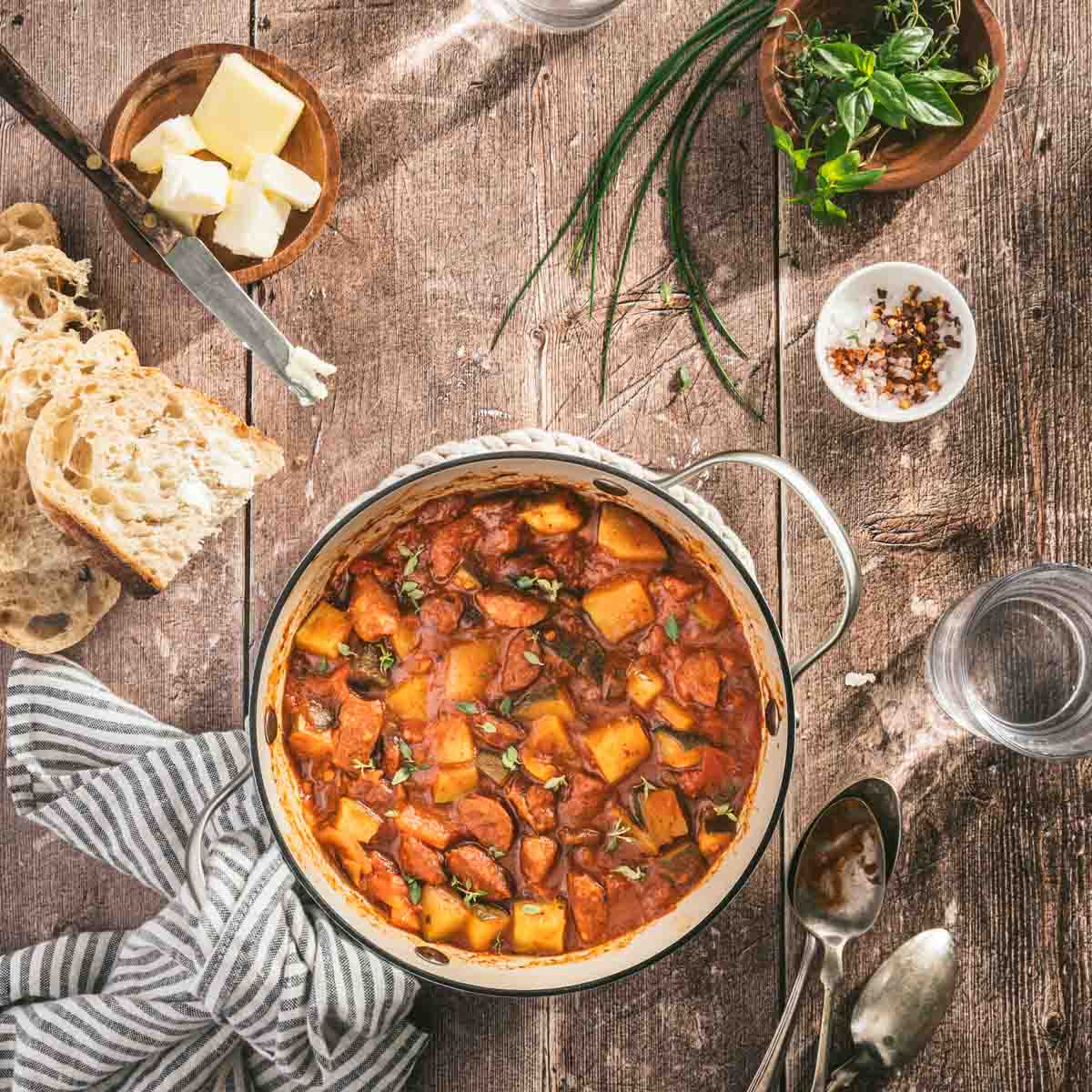 eczo in a pan, napkin, slices of bread, fresh herbs, spoons