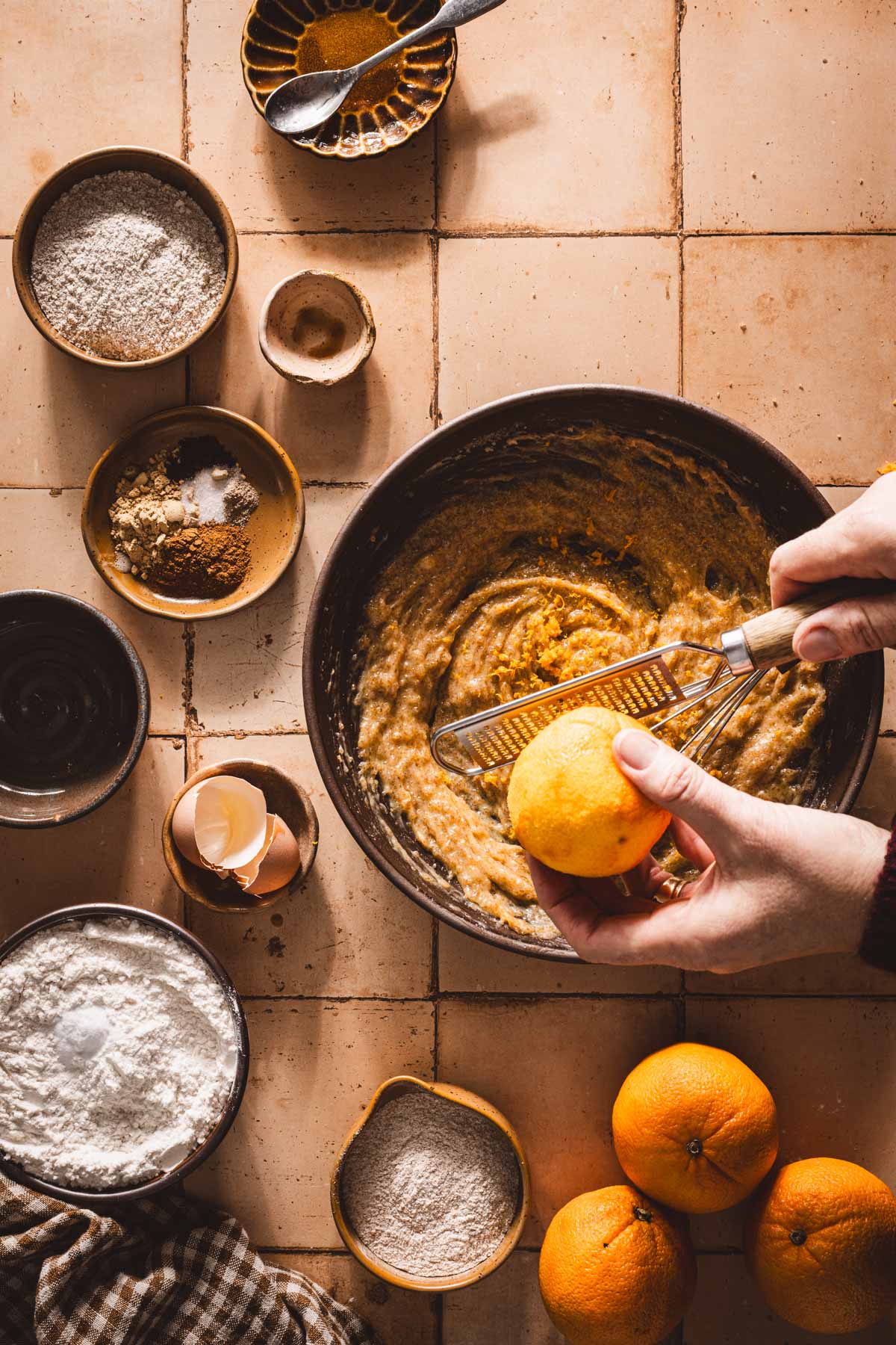 hands in frame adding orange zest