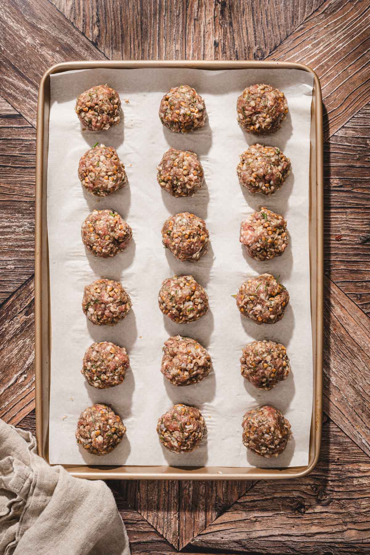 raw meatballs on a baking sheet