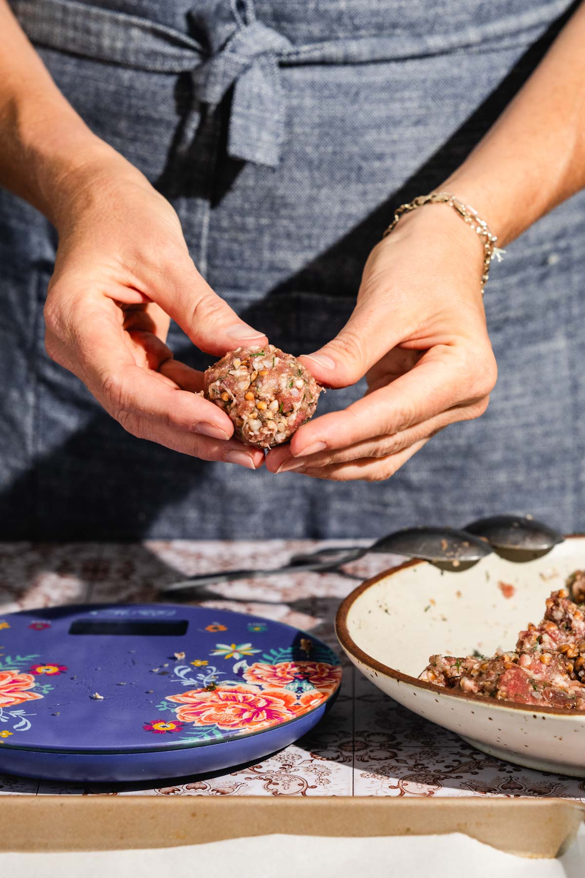 hands in frame holding formed meatball