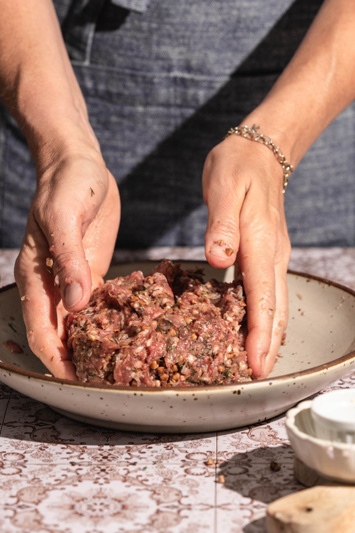hands in frame mixing meat for meatballs