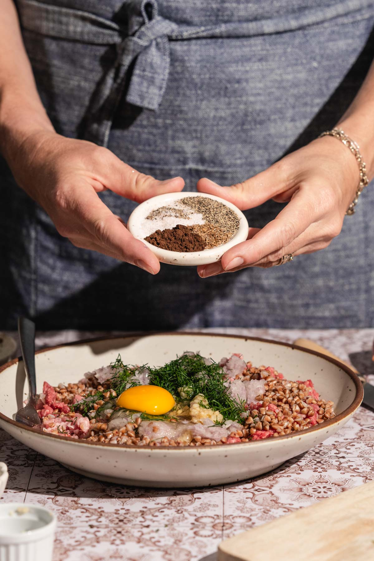 hands in frame holding dish with spices