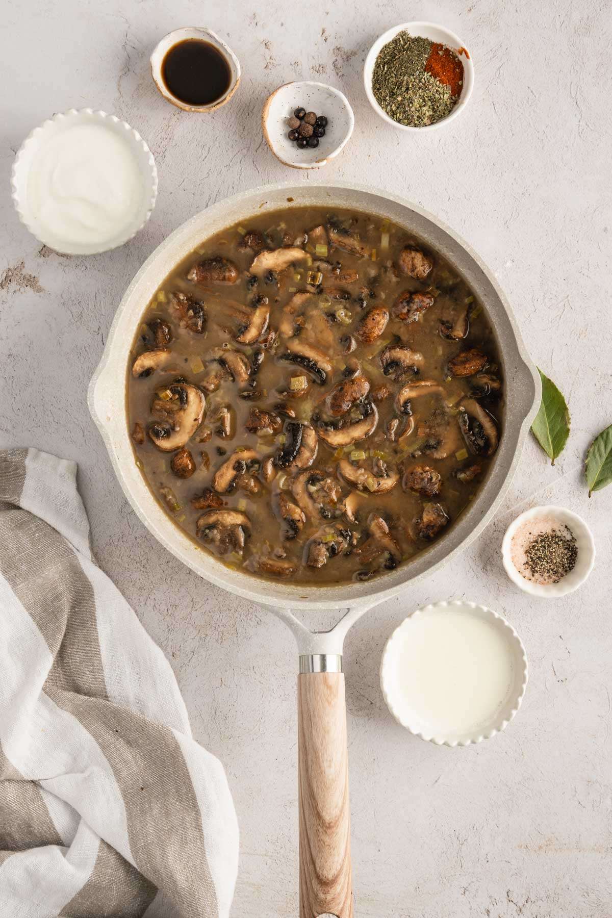 skillet with mushroom sauce, small dishes with other ingredients around