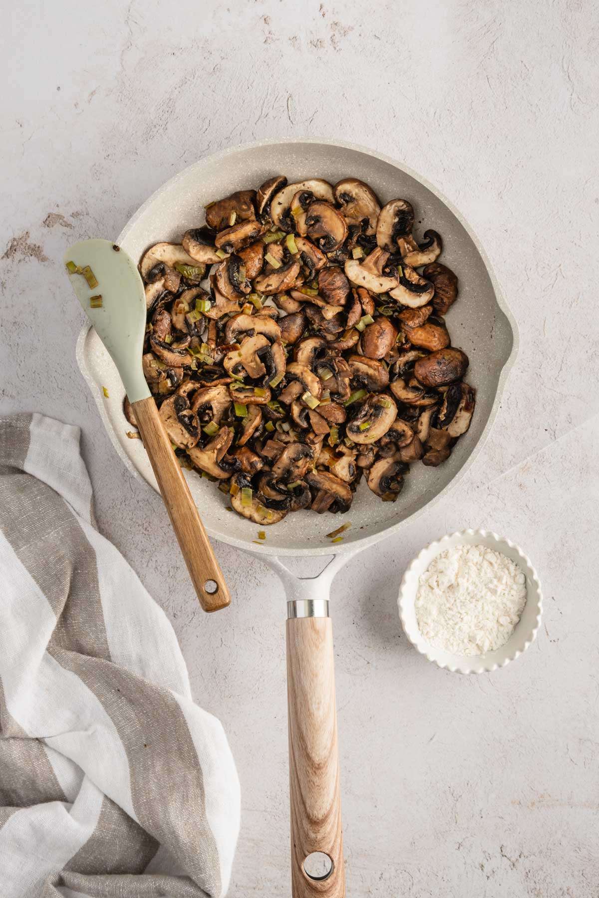 skillet with cooked mushrooms in it, dish with flour