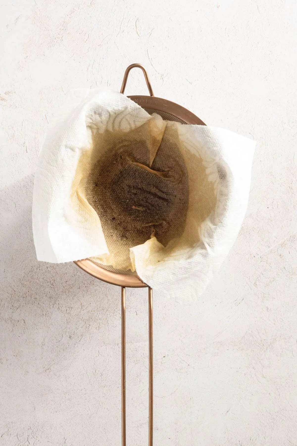 strainer with paper towel stained with mushroom water