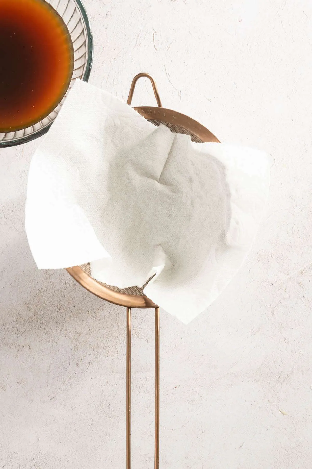 strainer with paper towel, bowl with mushroom water