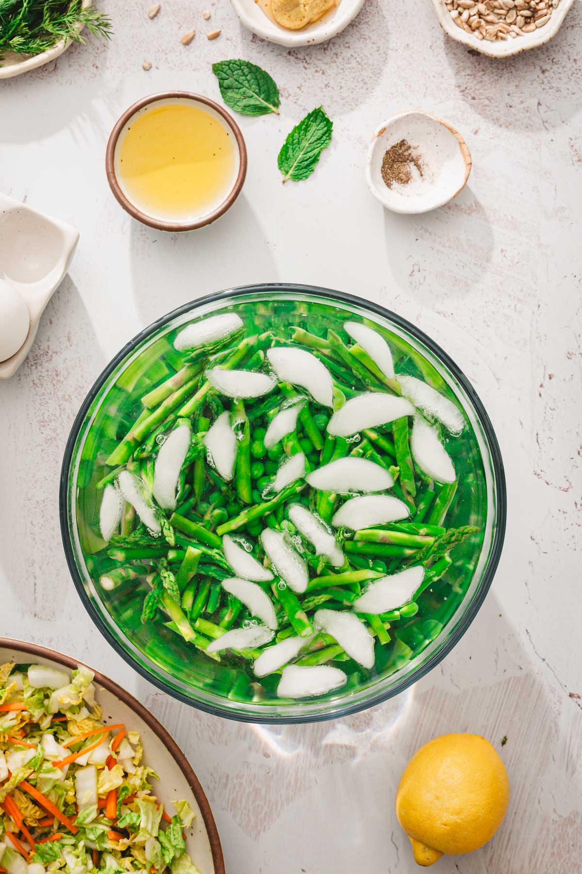 large glass bowl with icedwater and asparagus