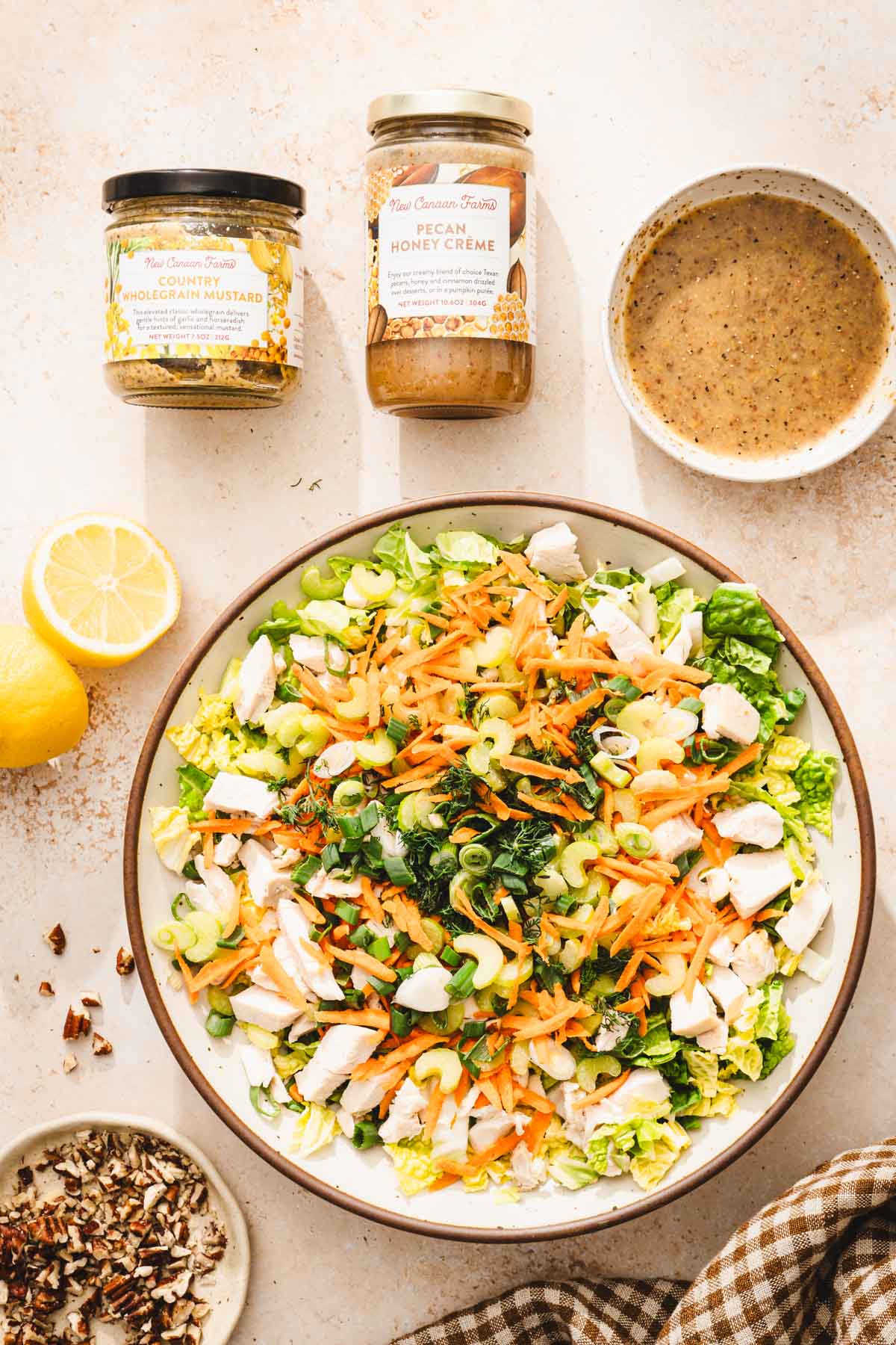 large bowl with prepared salad, dish with dressing, brand jars, napking