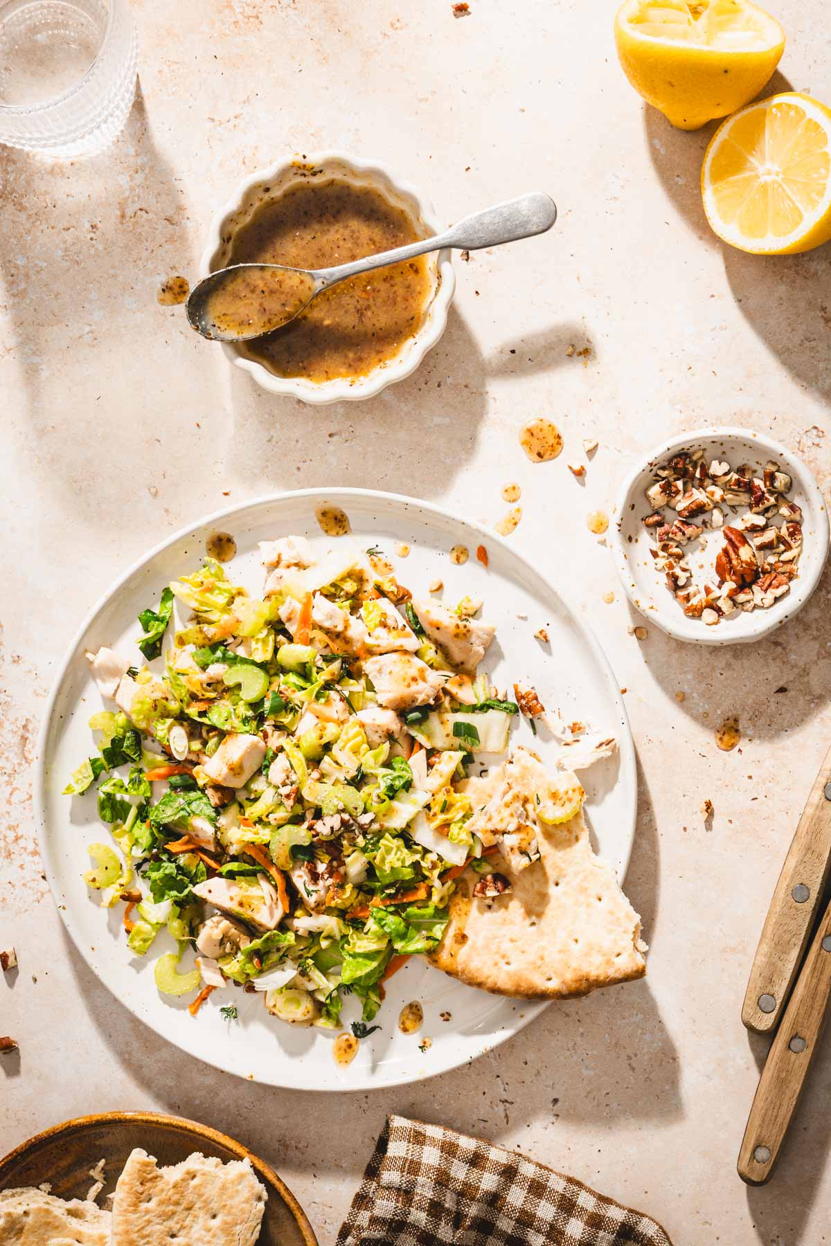 plate with napa salad, dish with dressing, serving spoon