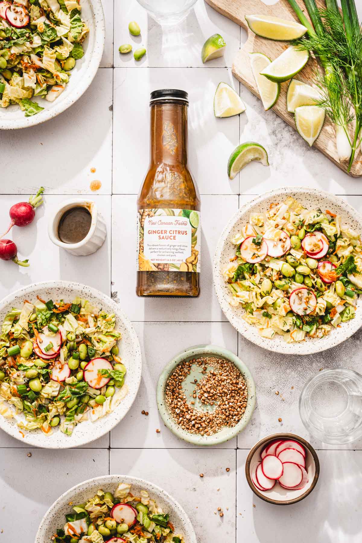 various bowls with the napa cabbage salad, bottle with brand dressing