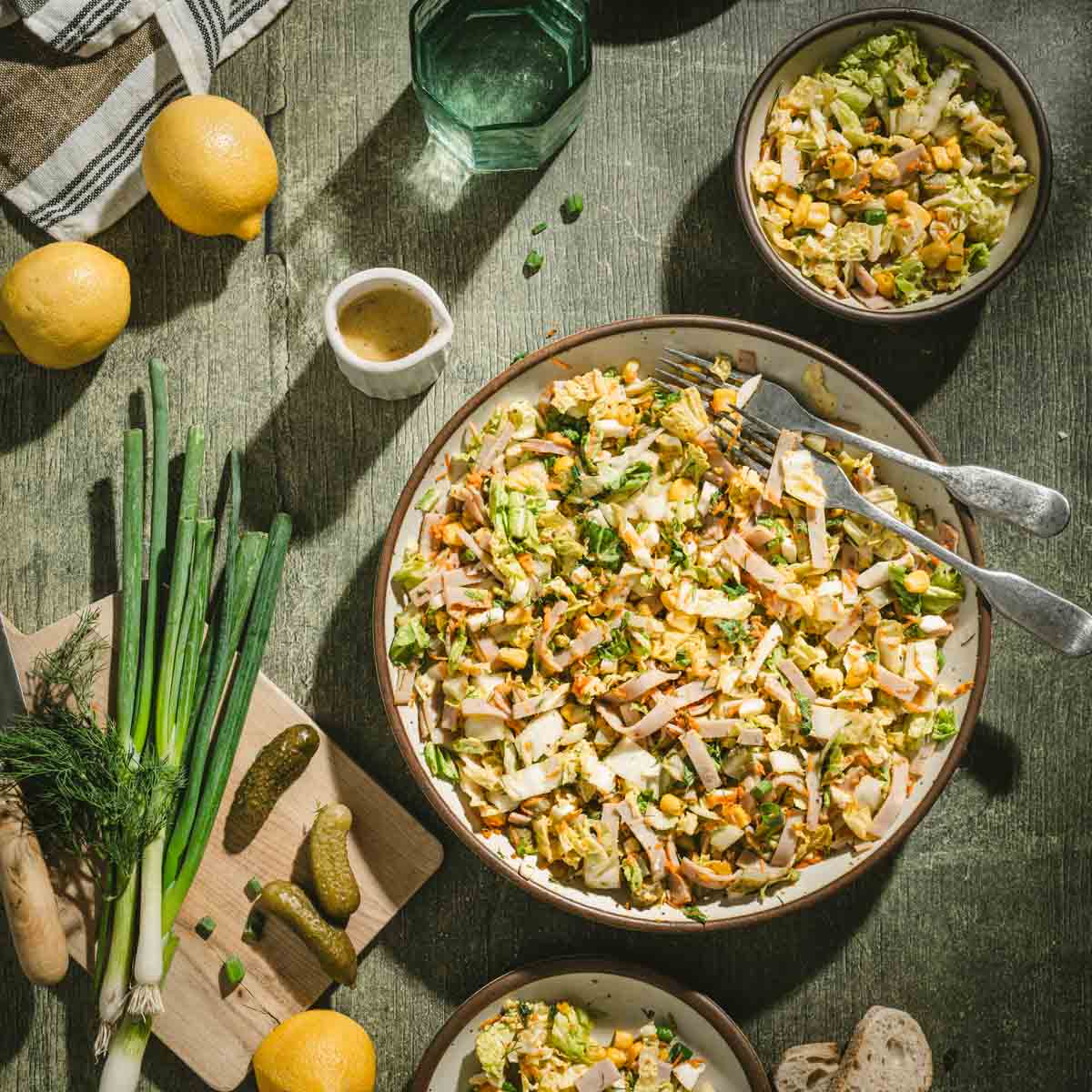 large serving bowl with napa salad, galss with water