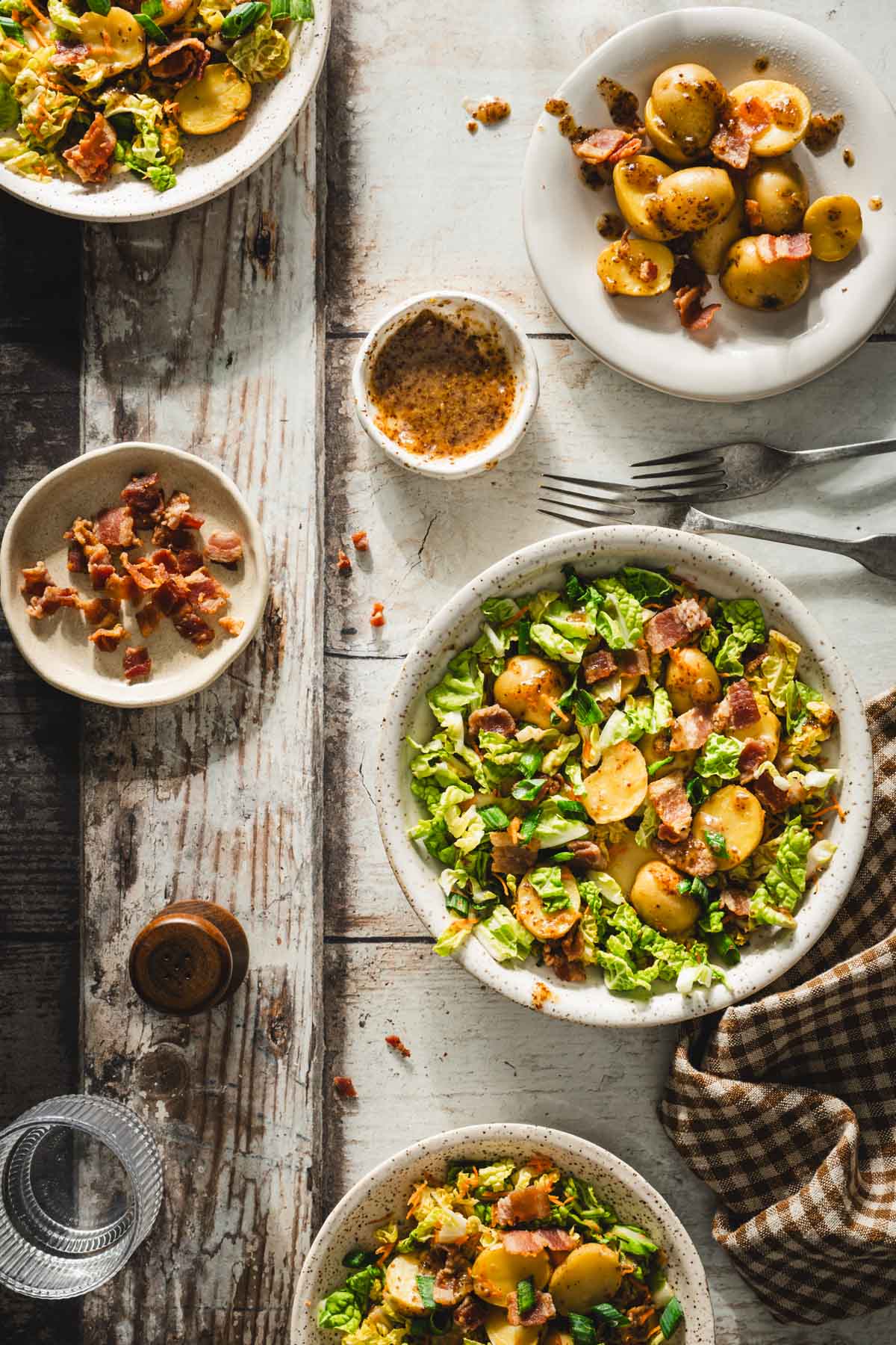 bowl with napa salad,two forks,dish with bacon