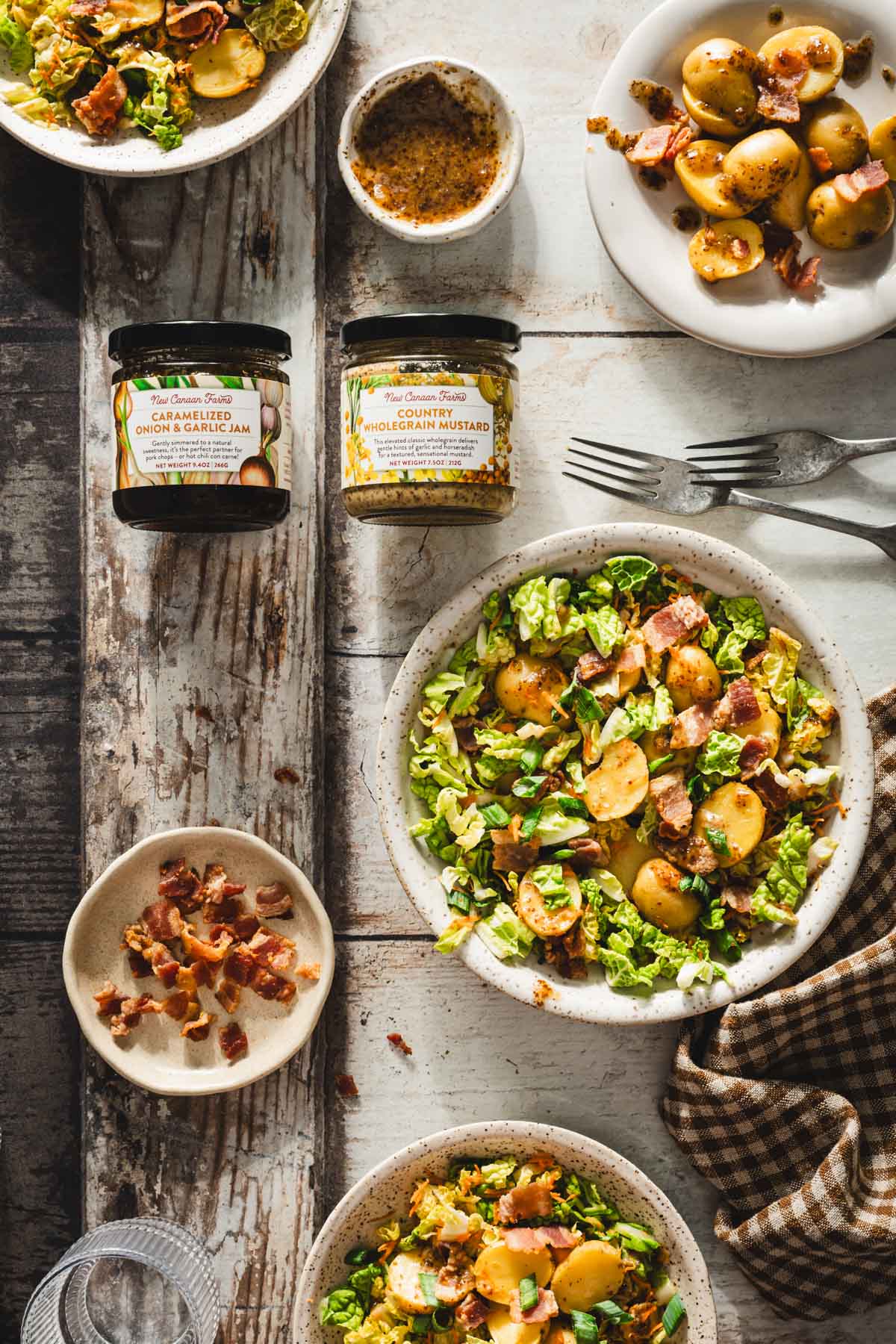 various bowls with napa salad, dish with cookd bacon, brandd jars