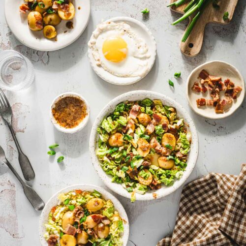 various plates with napa potato salad, plat with an egg, chives, sauc