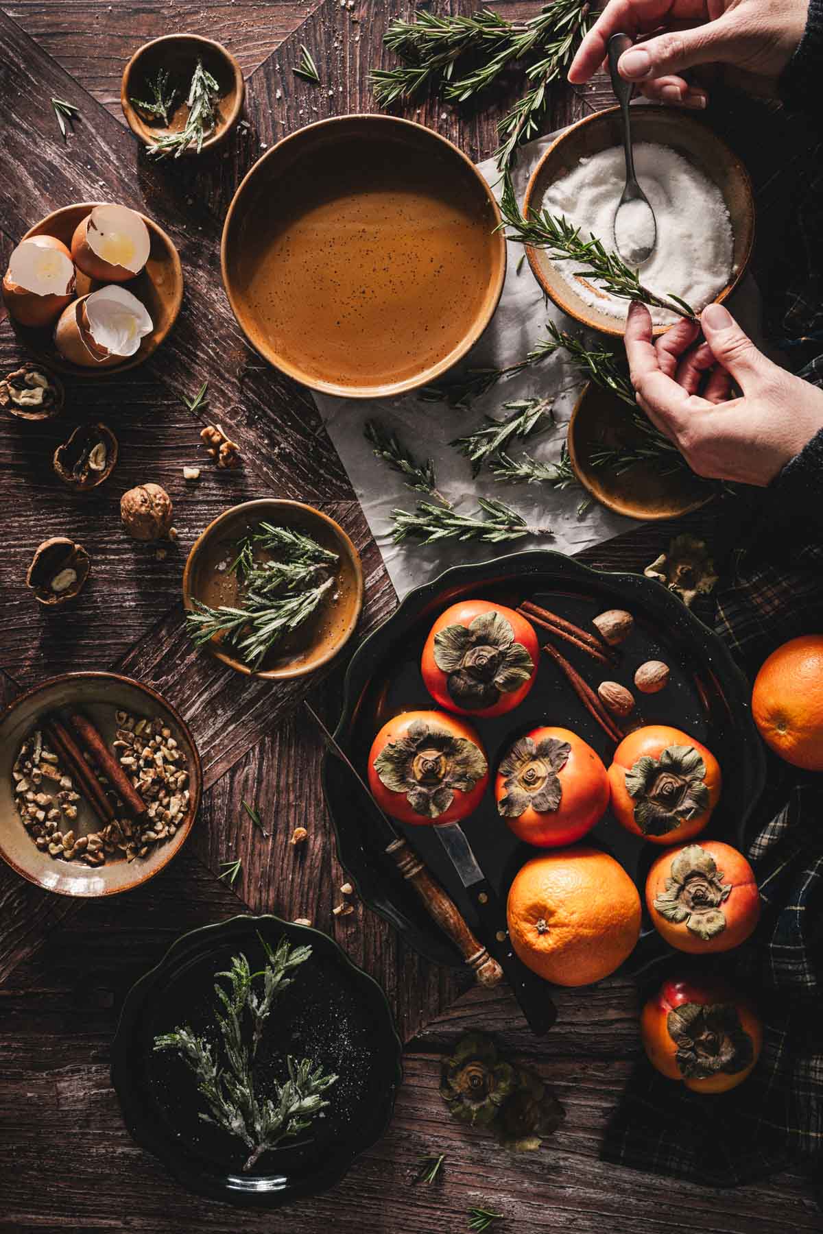 hands in frame sprinkling sugar over the rosemary