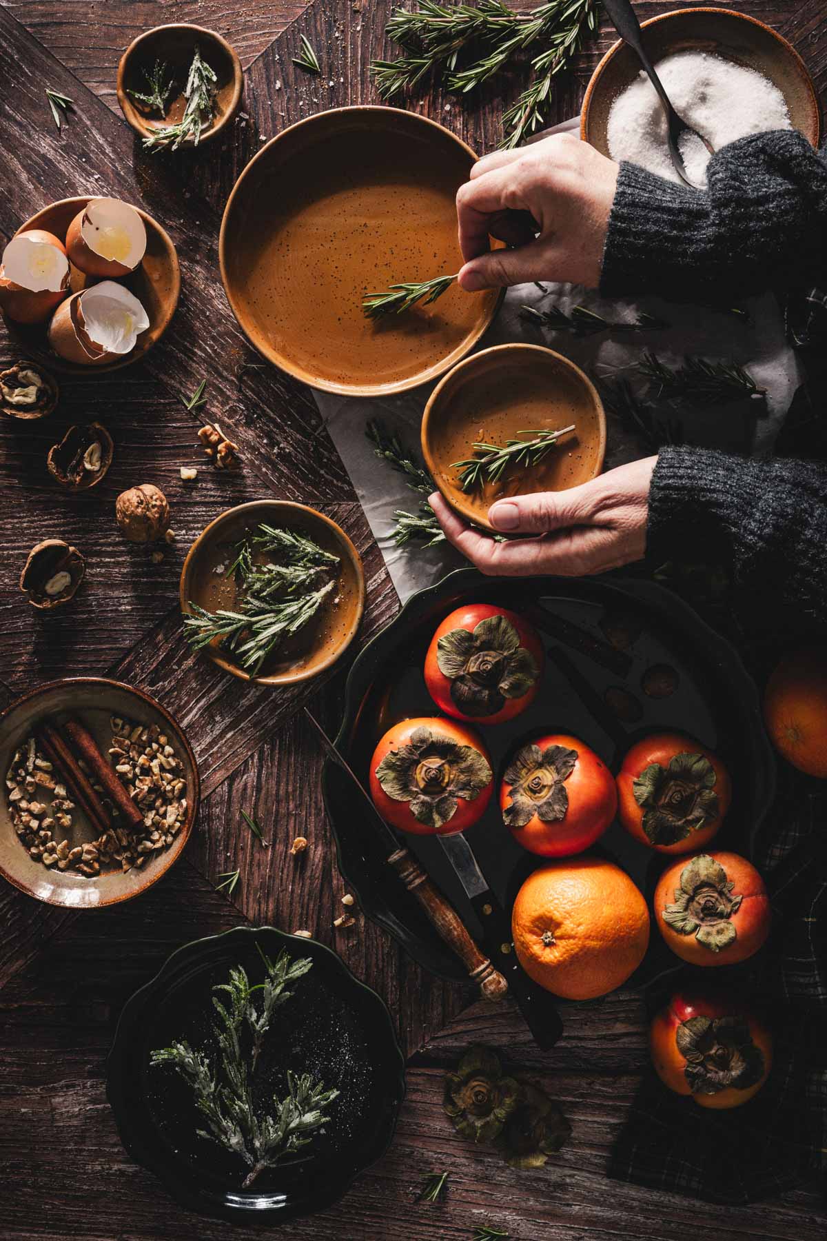 hands in frame dipping roseamry stem in simple syrup