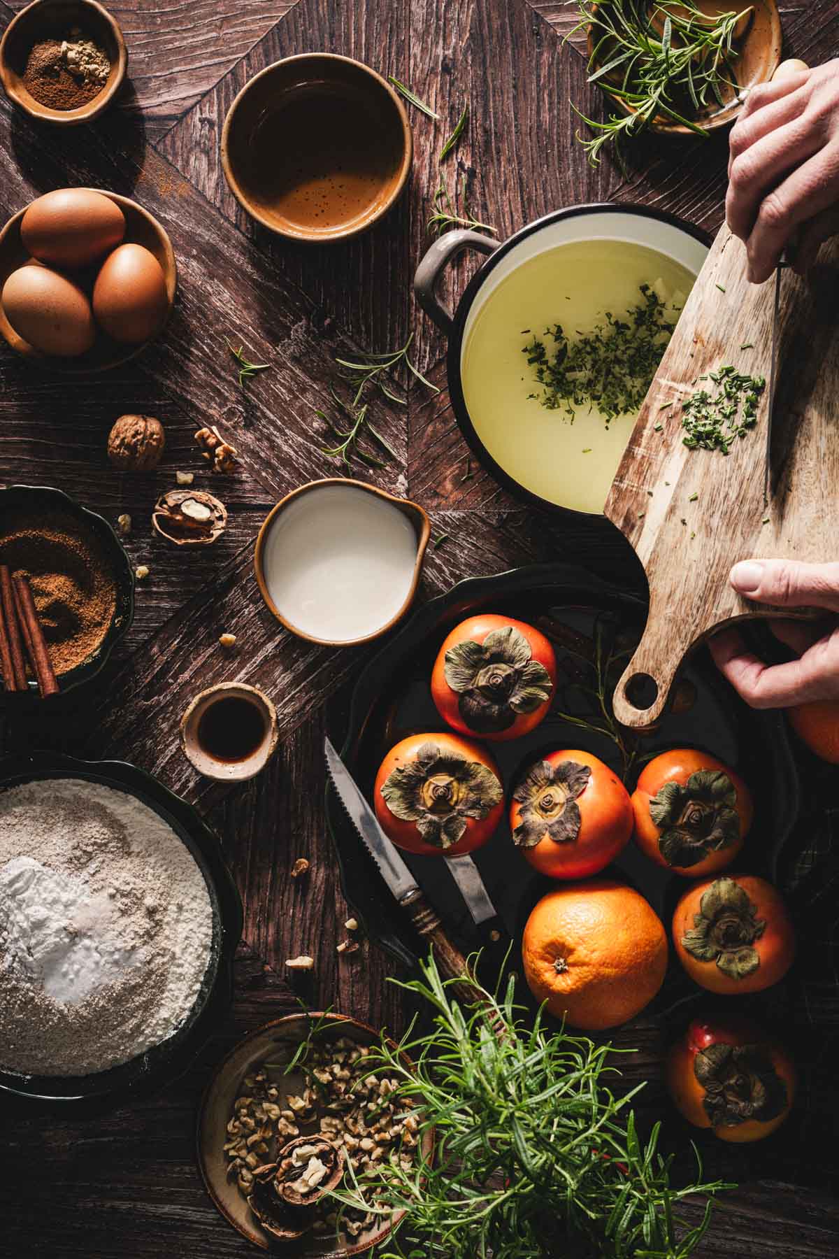 hands in frame holding cutting board with chopped rosemary