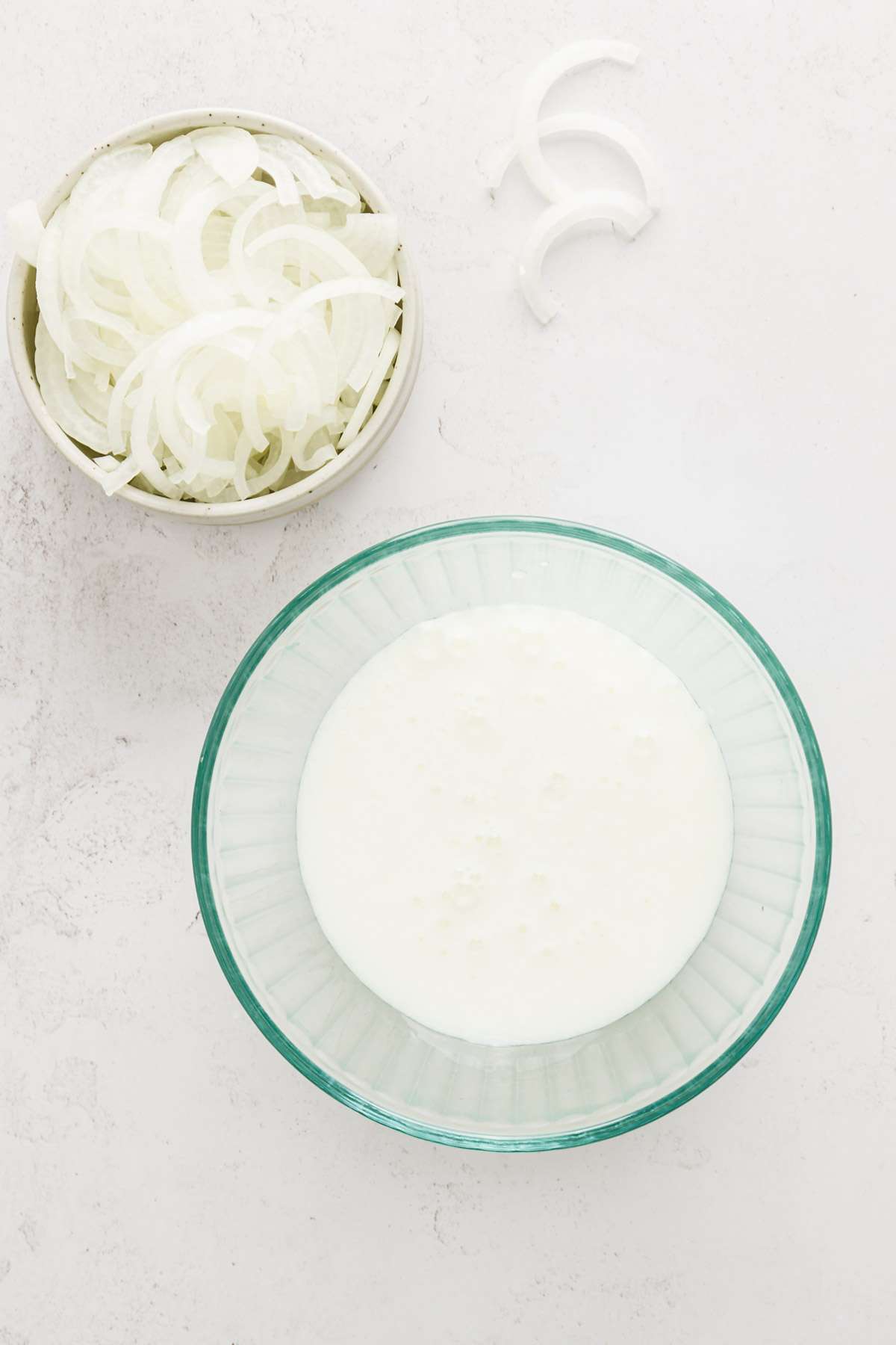 bowl with buttermilk, sliced onions on the side