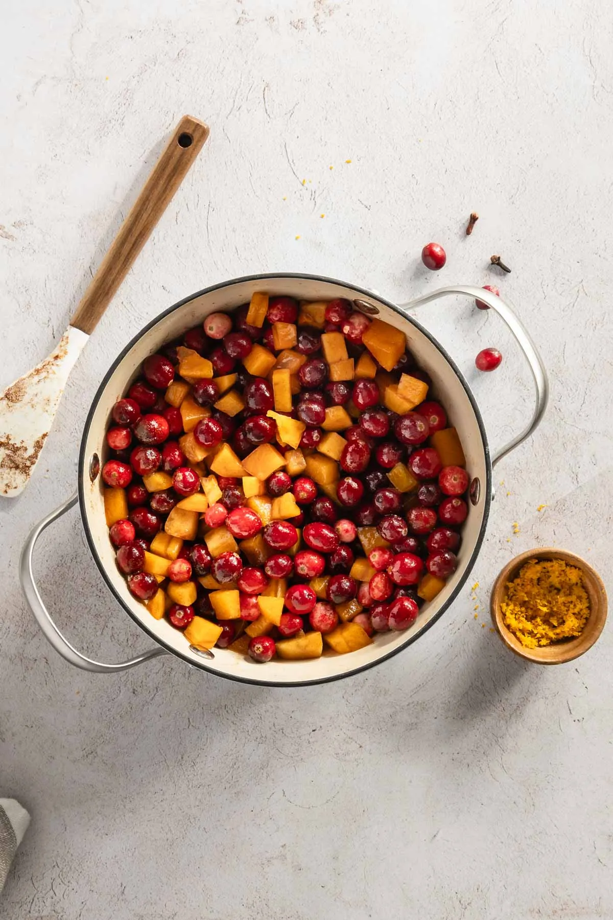 ingredients for the cranberry sauce in a cooking pan; small bowl with orange zest
