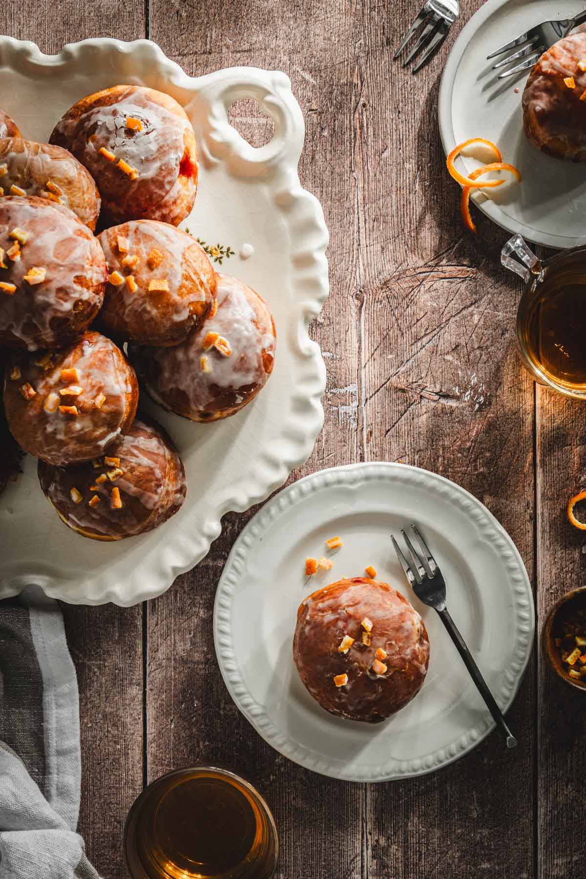 paczki on platter, few plates around, two glasses with tea