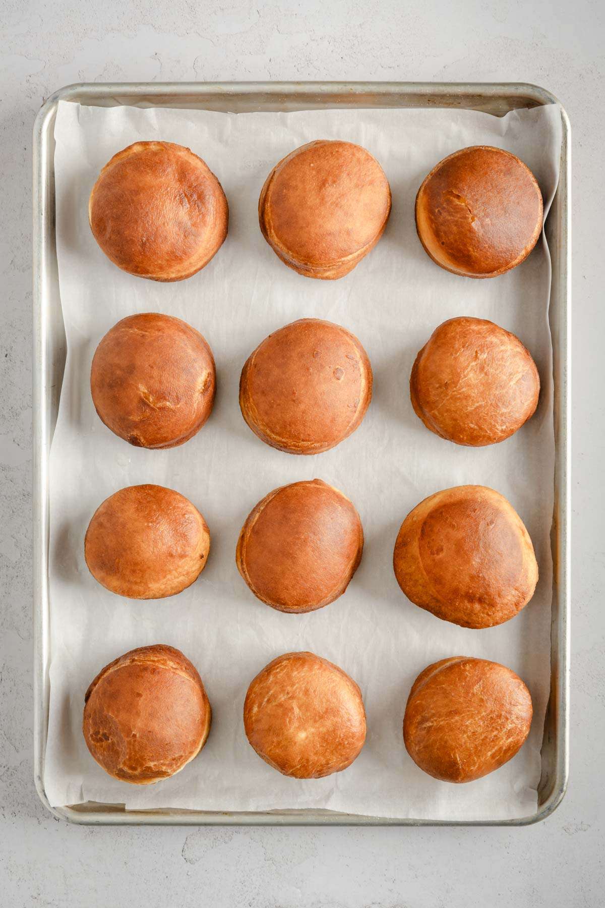 finished paczki on a baking sheet