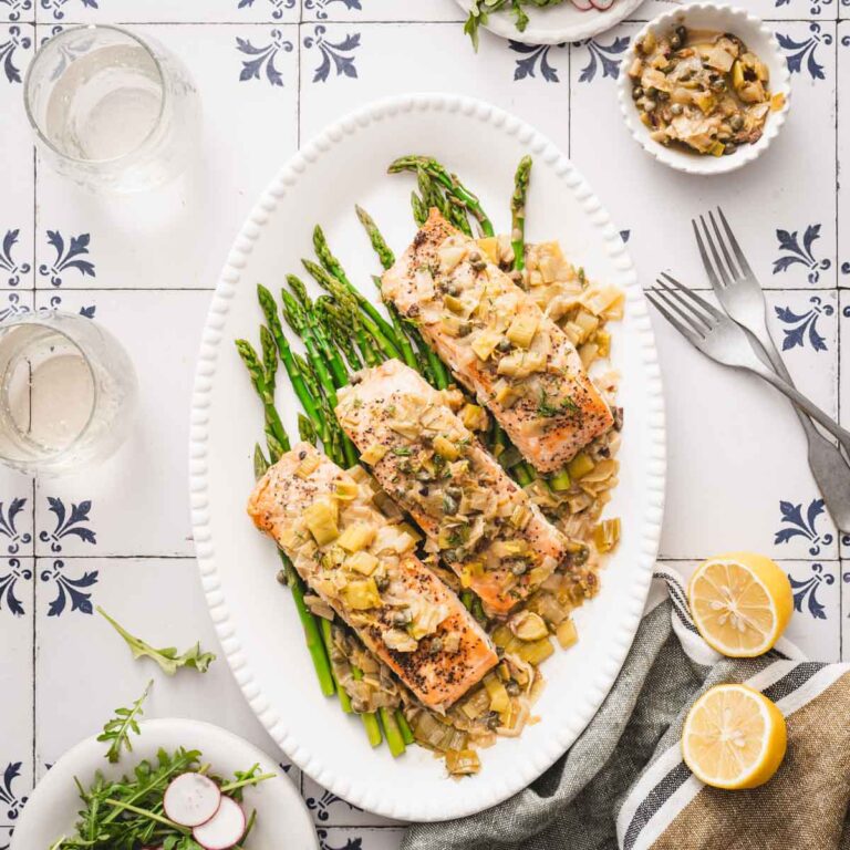 pan sared salmon in leeks and mustard sauce on a serving platter