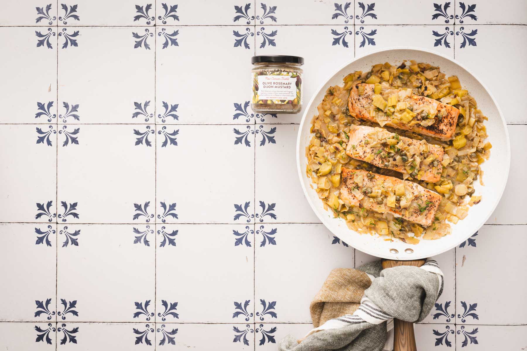 salmon in a skillet, jar with mustard