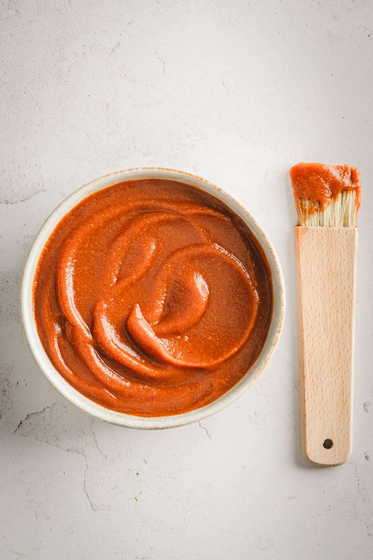 Peach BBQ Sauce in a serving bowl with a sauce brush