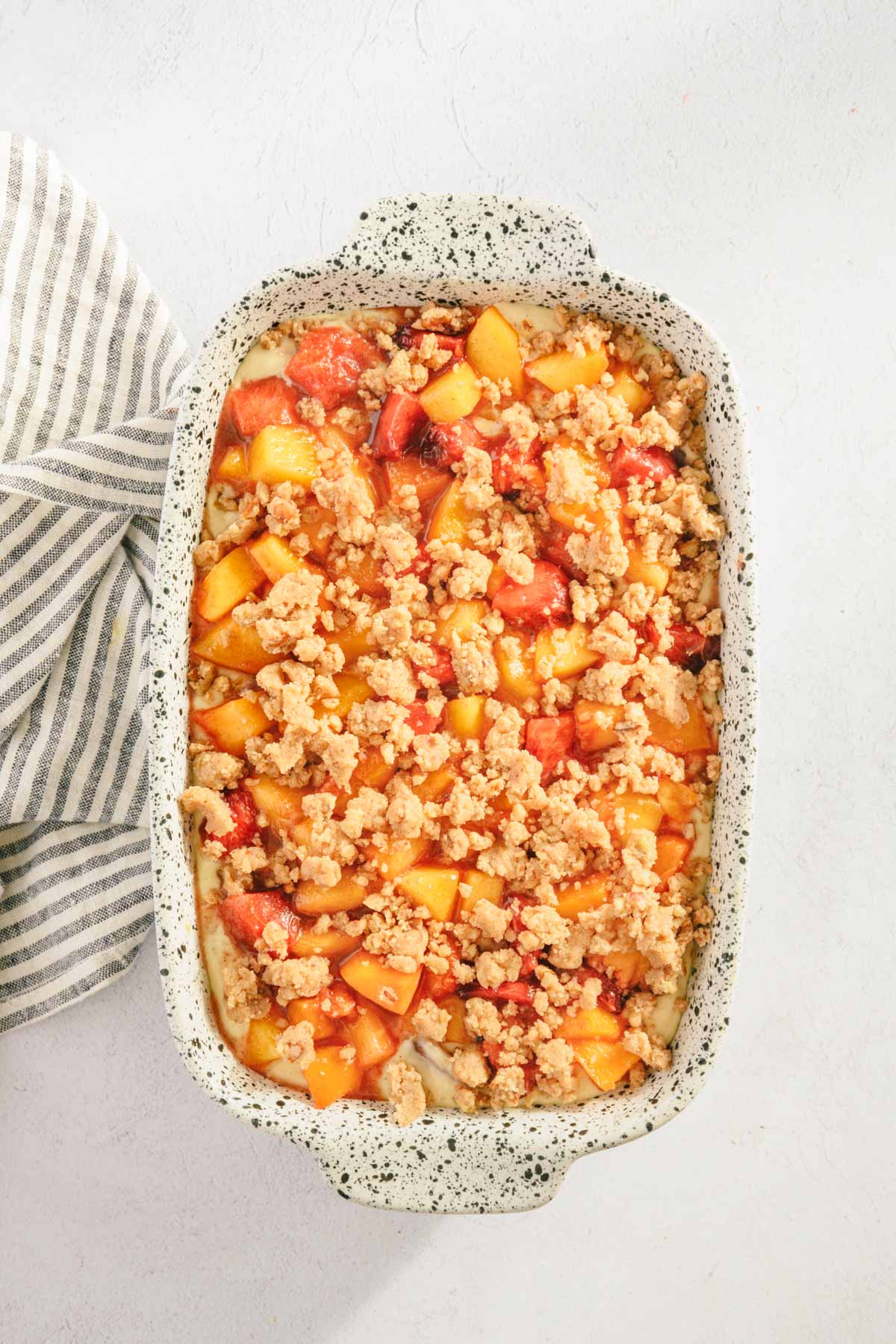 rest of the crumble added on top of the fresh peaches