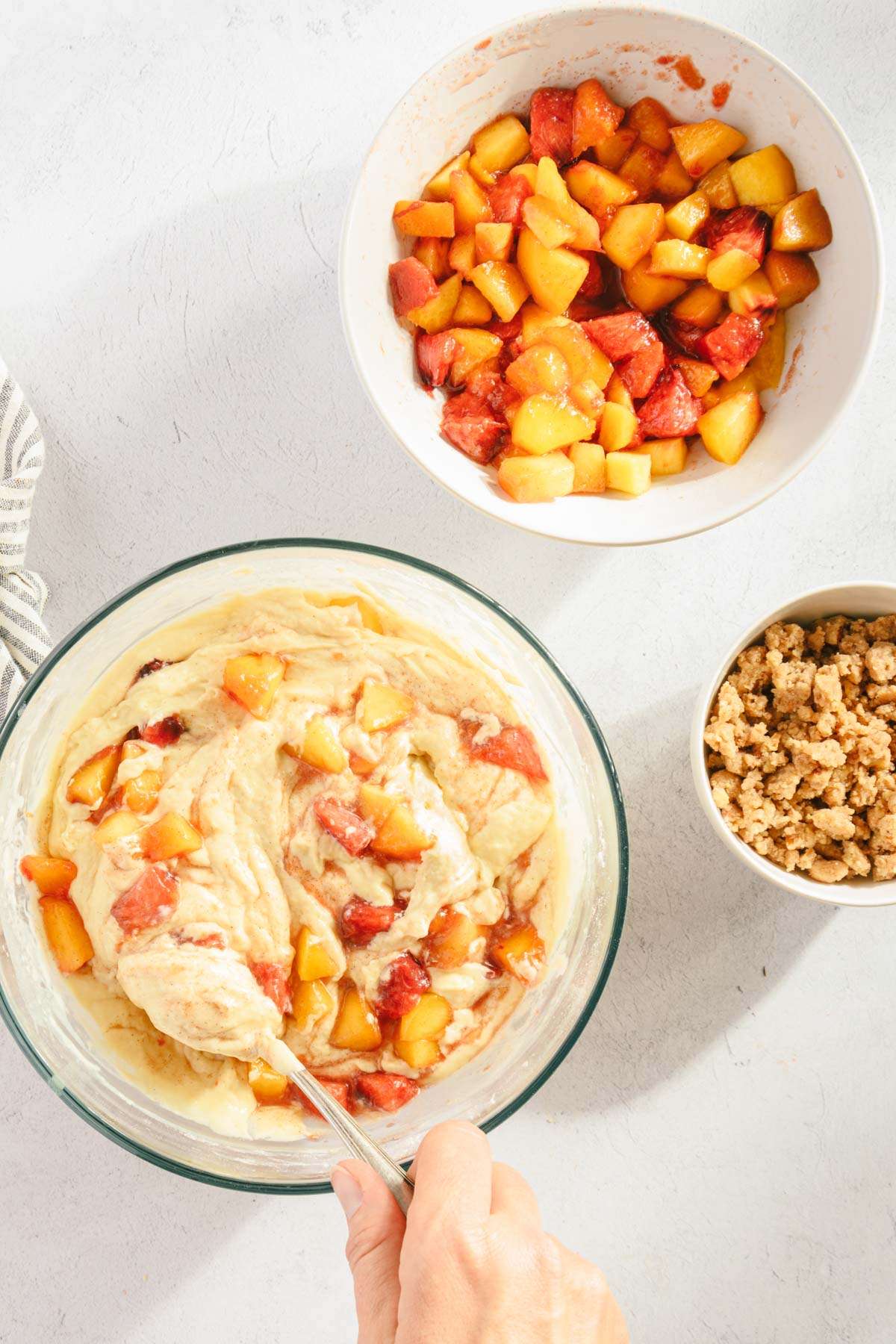 bread batter with mixed in peaches, bowl with crumble and rest of the peaches