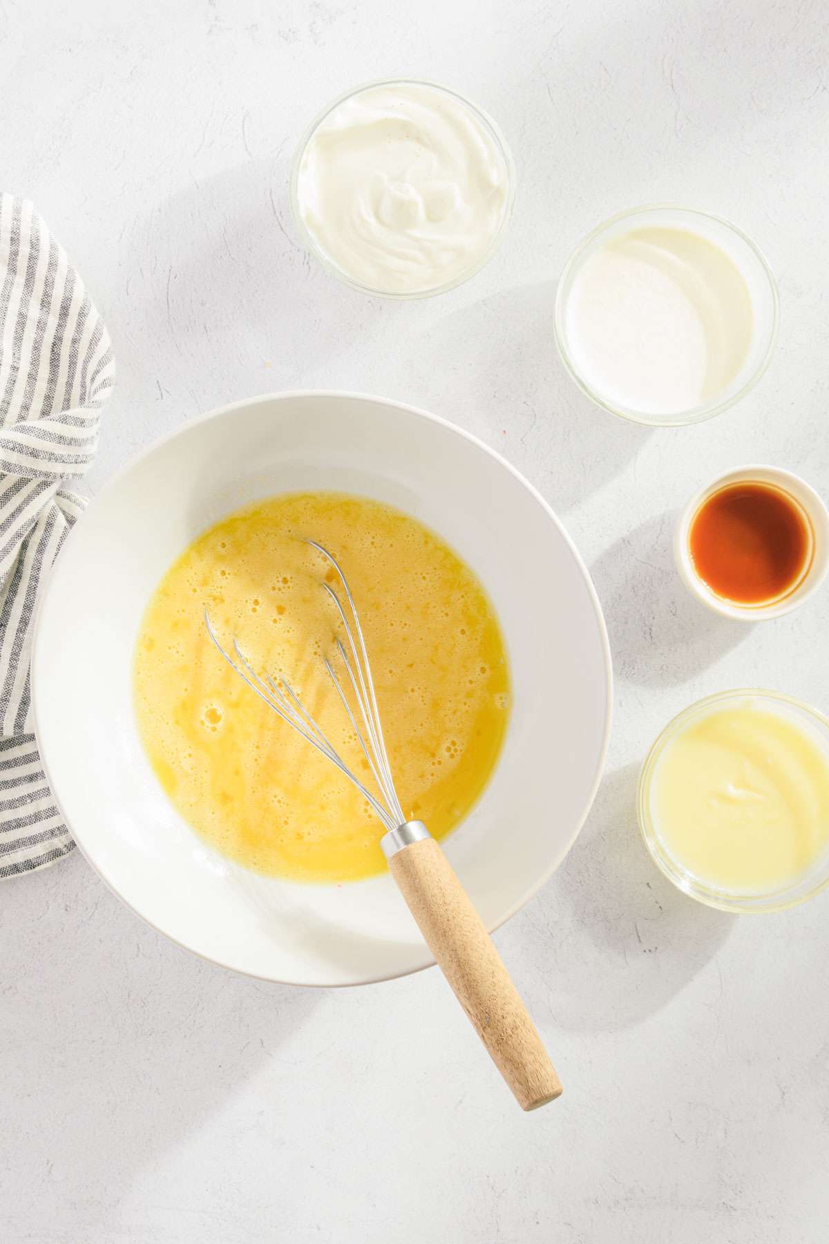 bowl with egg and sugar and additional ingredients for the bread batter set around