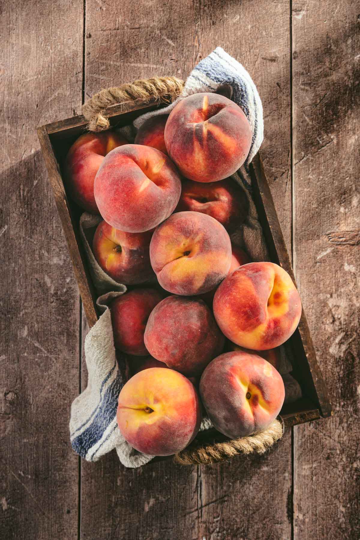 fresh peaches in a wooden tray