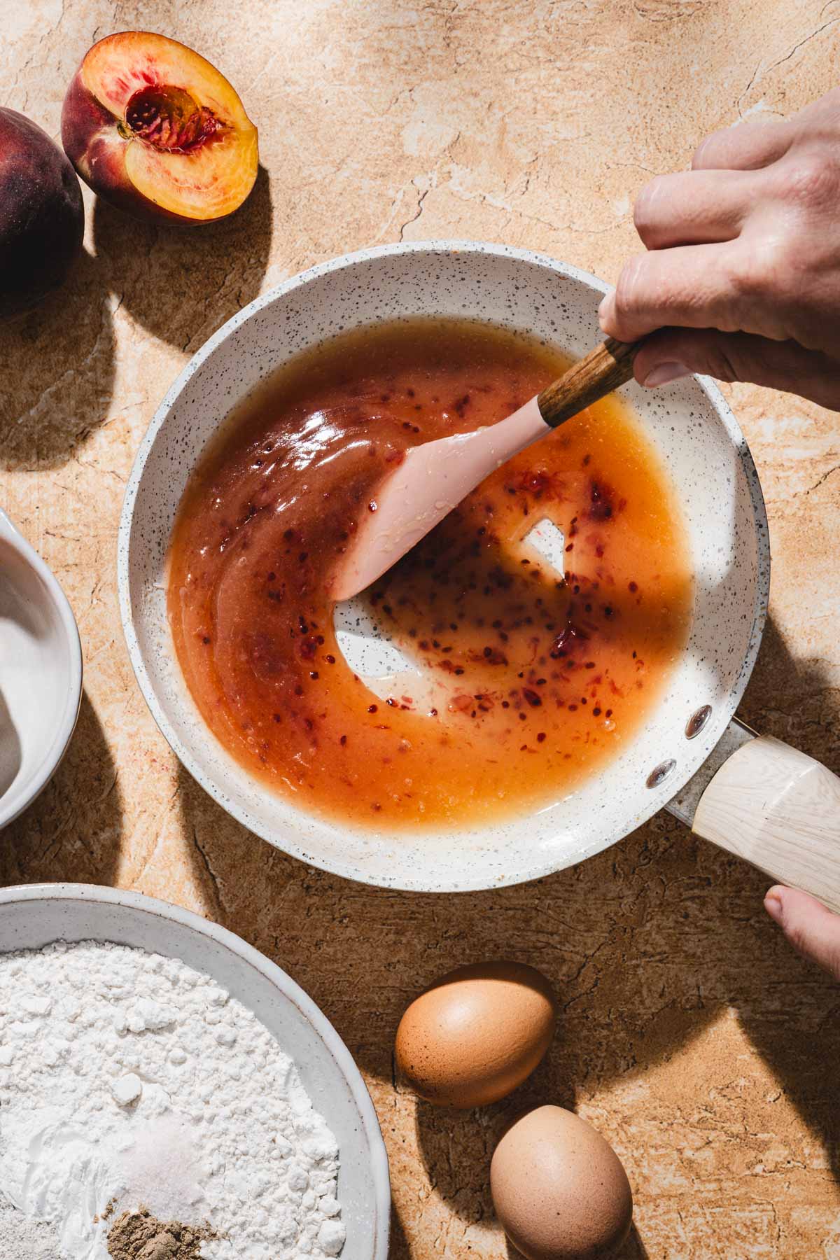 hands in frame stirring caramel on the skillet