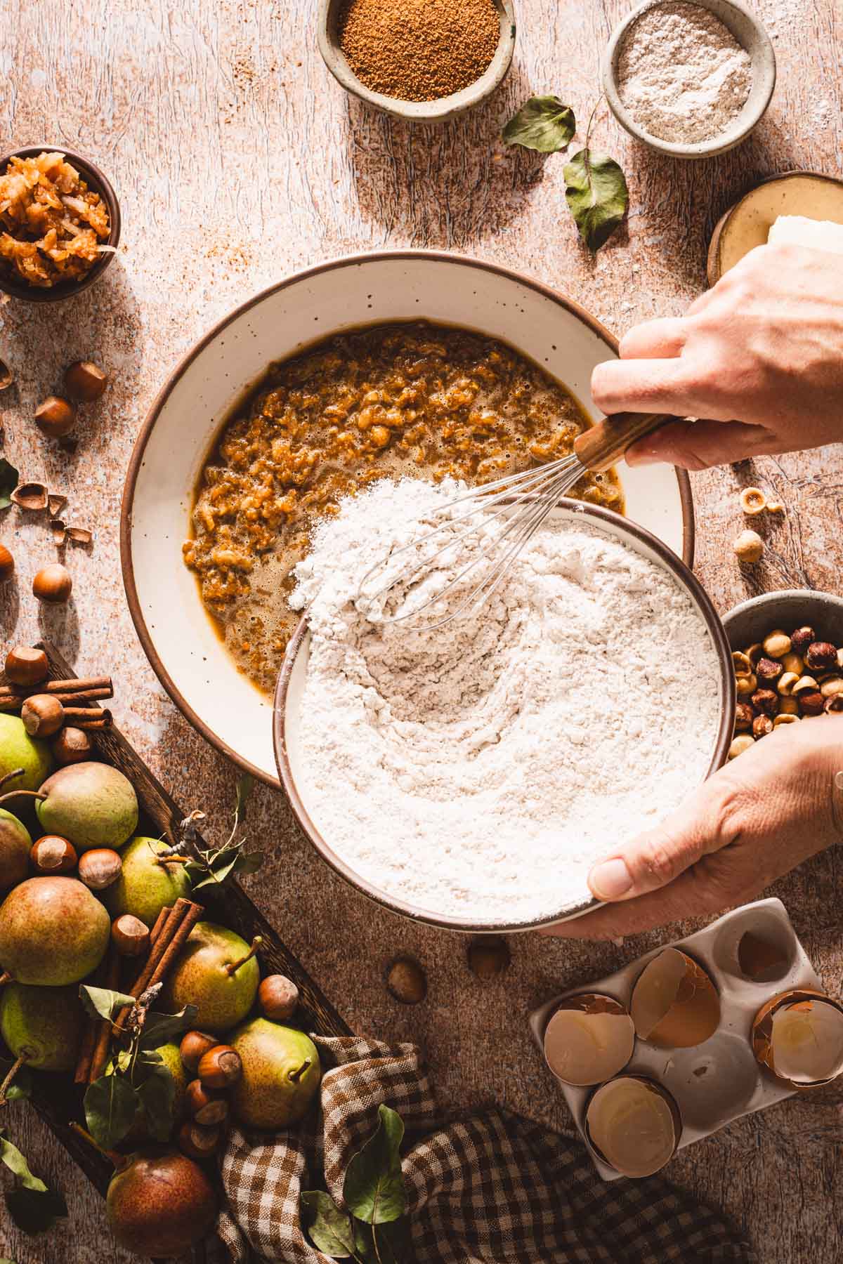 hands in frame adding flour to the wet ing