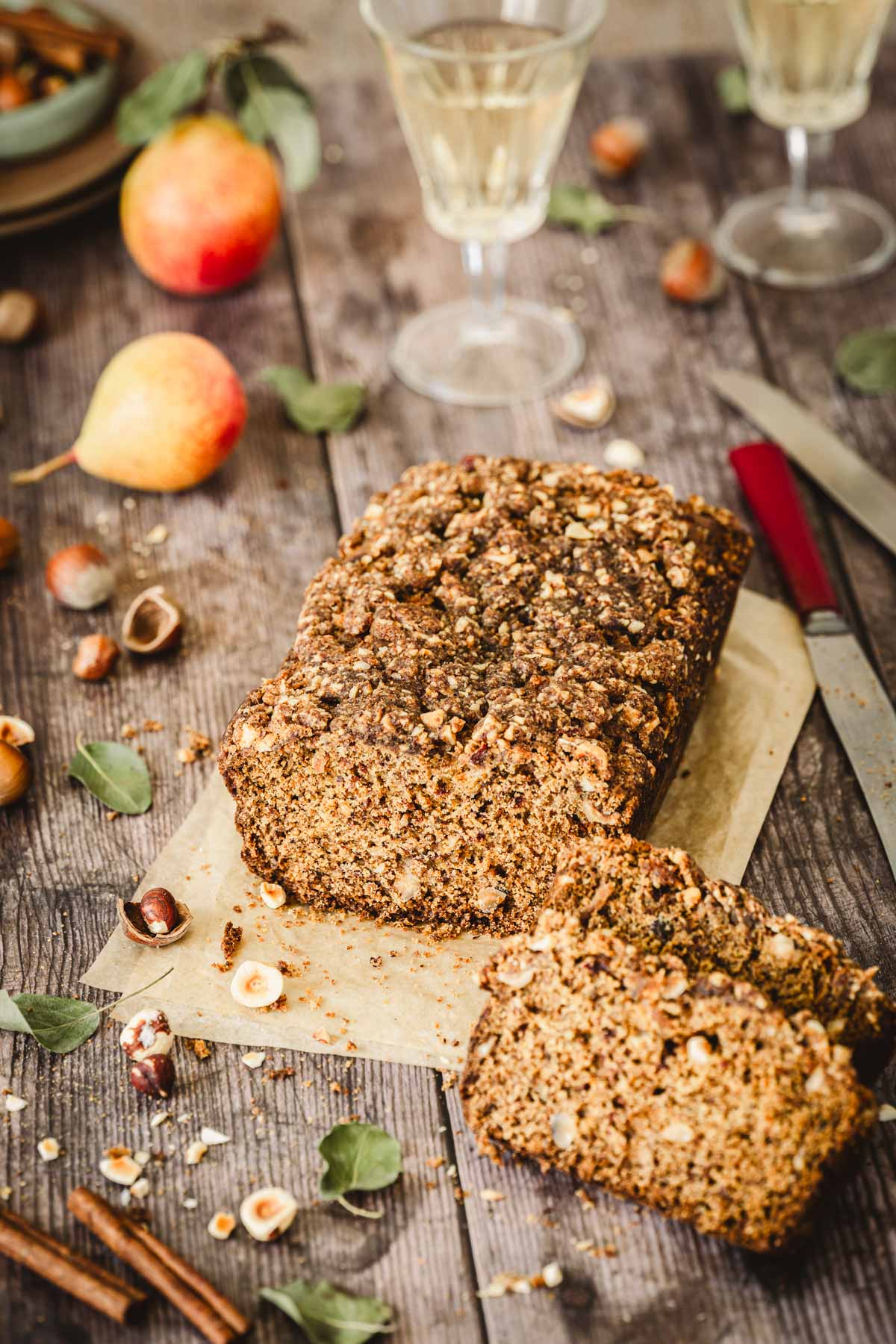 pear bread on a parchment paper, glasses with wine