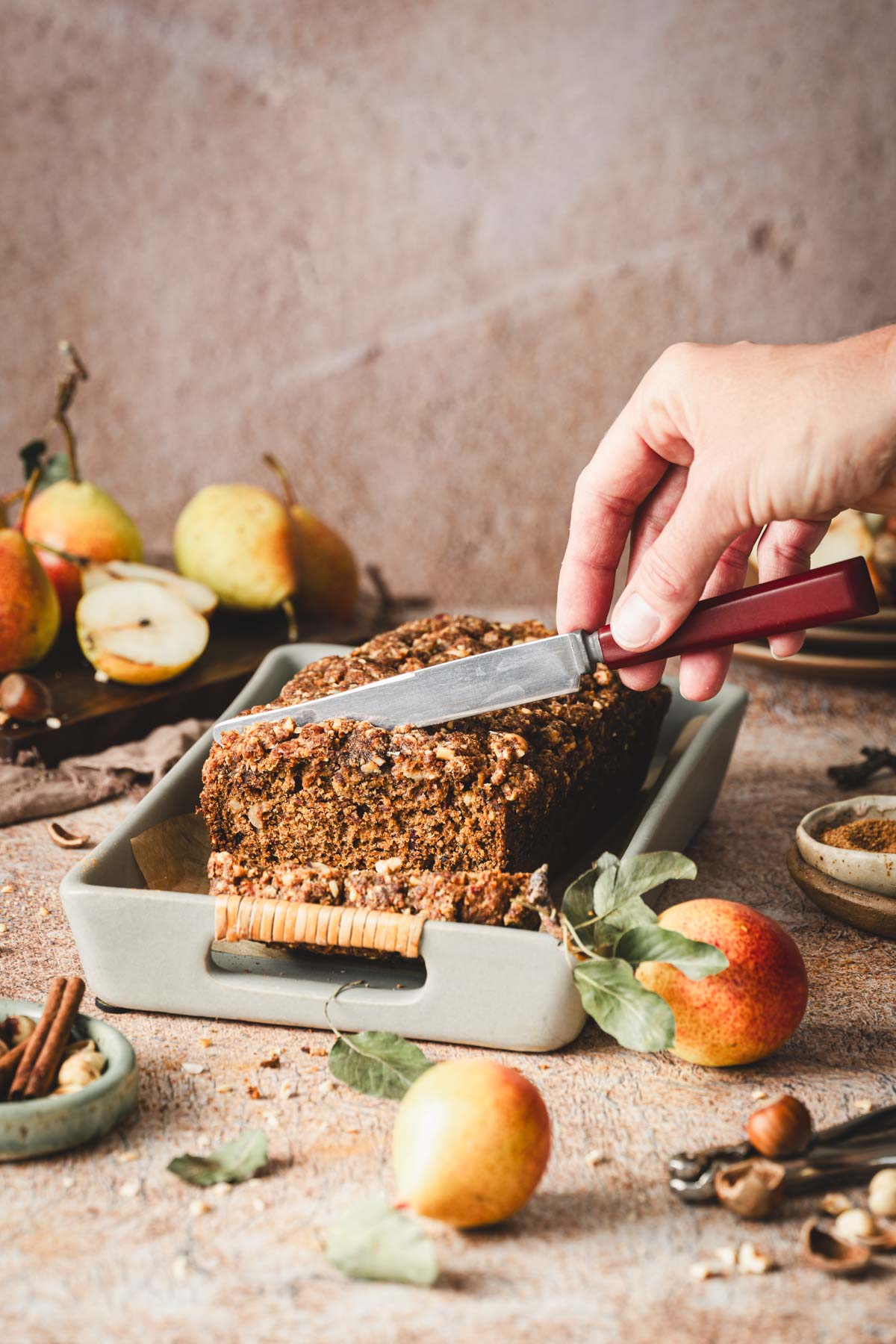 hands in frame slicing the pear bread