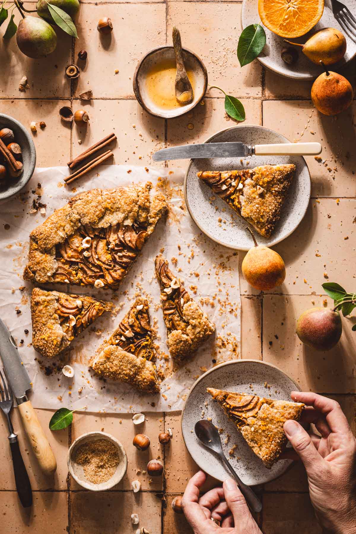 hands in frame holding plate with a slice of galette