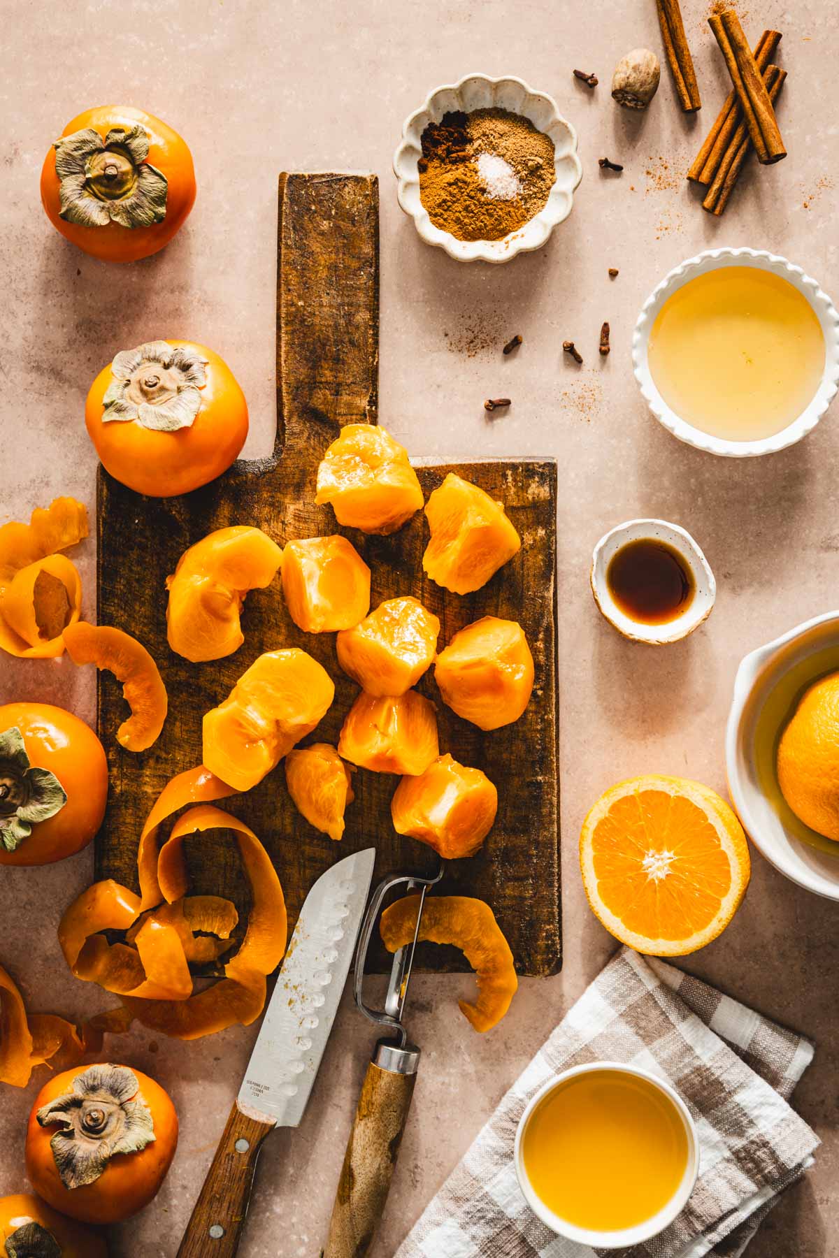 peeled and cut persimmons on a cutting boars, other ingredients around