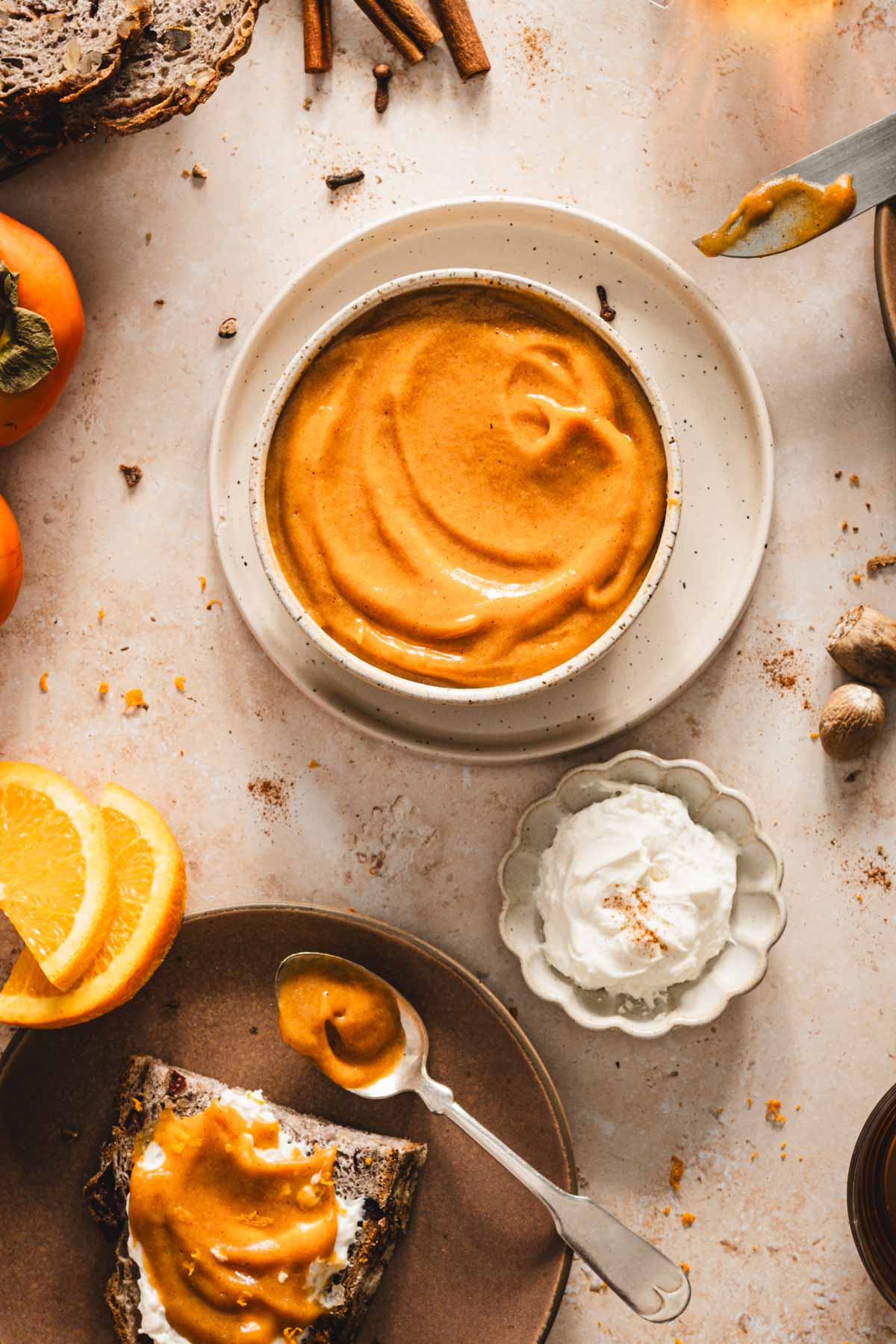 persimmon butter in a serving bowl, plate with slice of bread