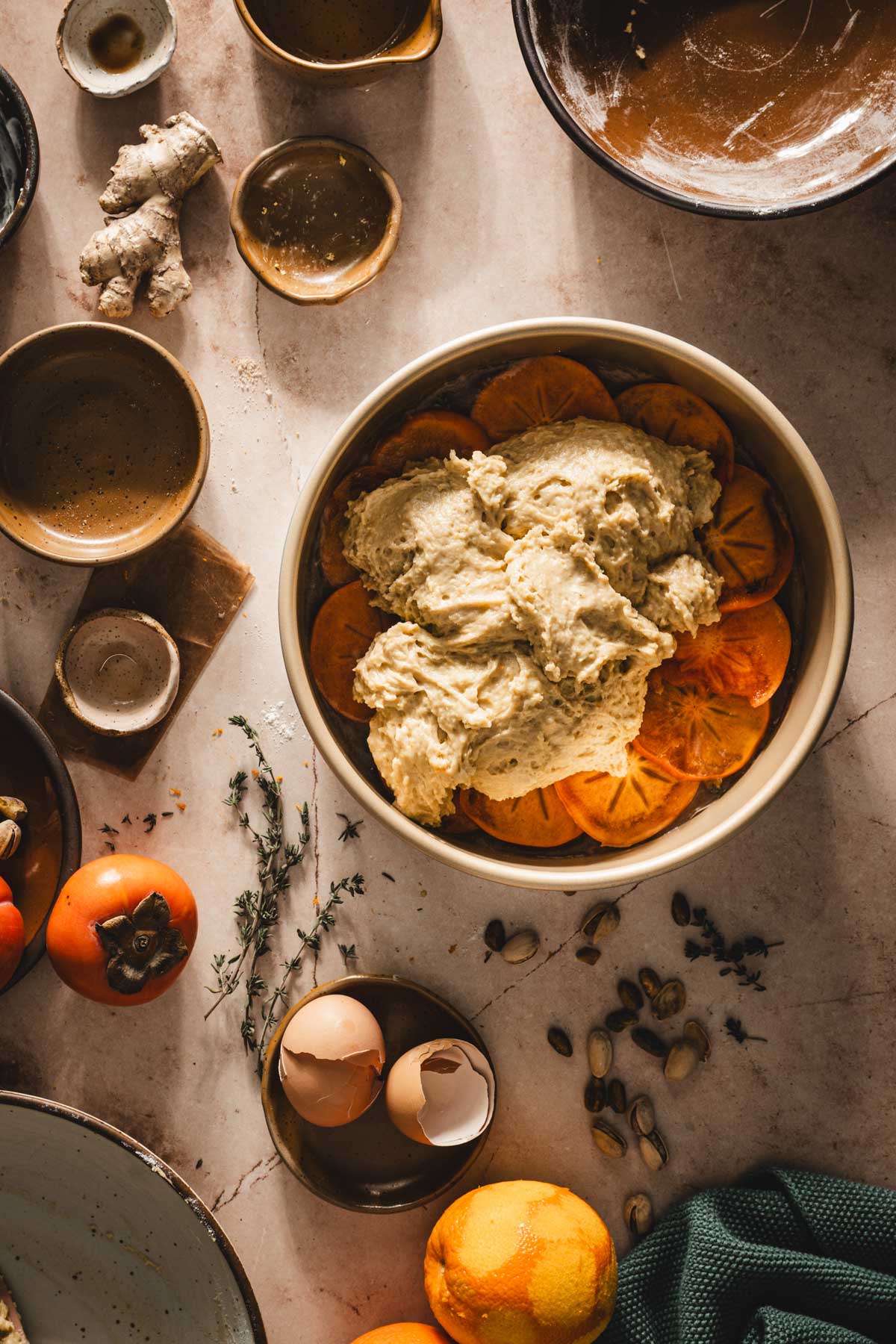 baking pan with batter added on top of the sliced persimmons