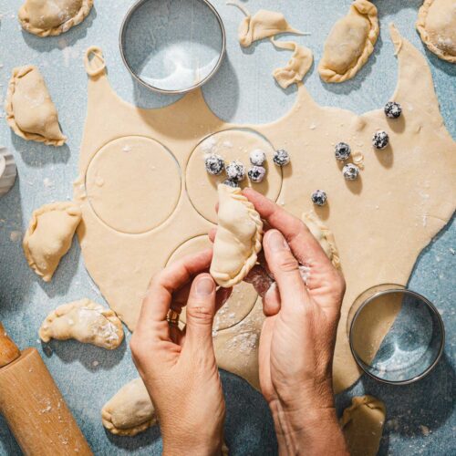 hands in frame holding pierogi